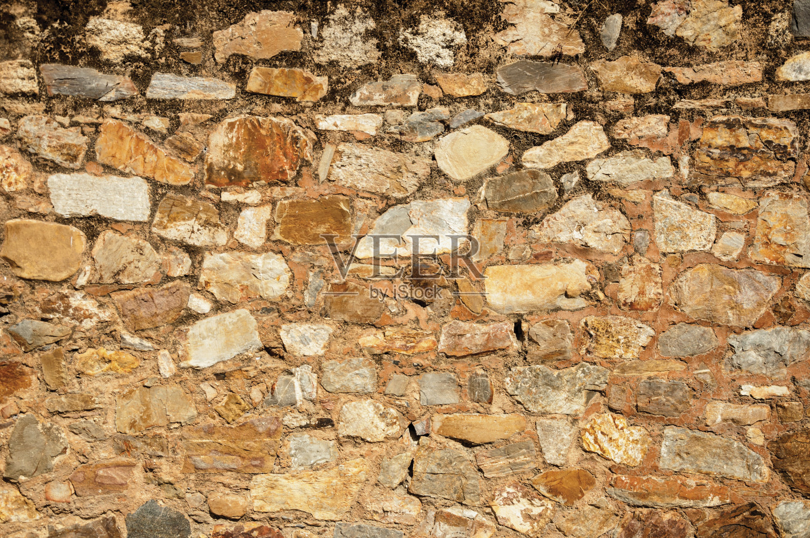 在卡塞雷斯，用粗糙的石头砌成的古老墙构成了迷人的背景照片摄影图片