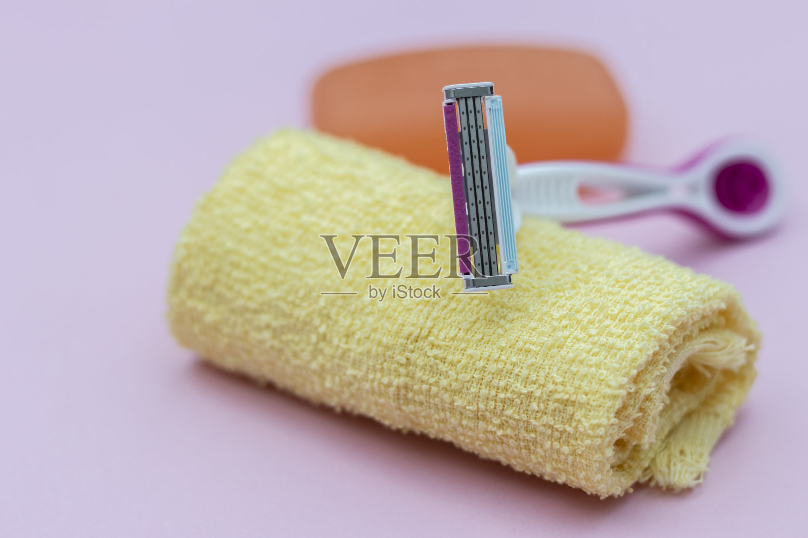 脱毛刀片和毛巾，粉红色背景照片摄影图片