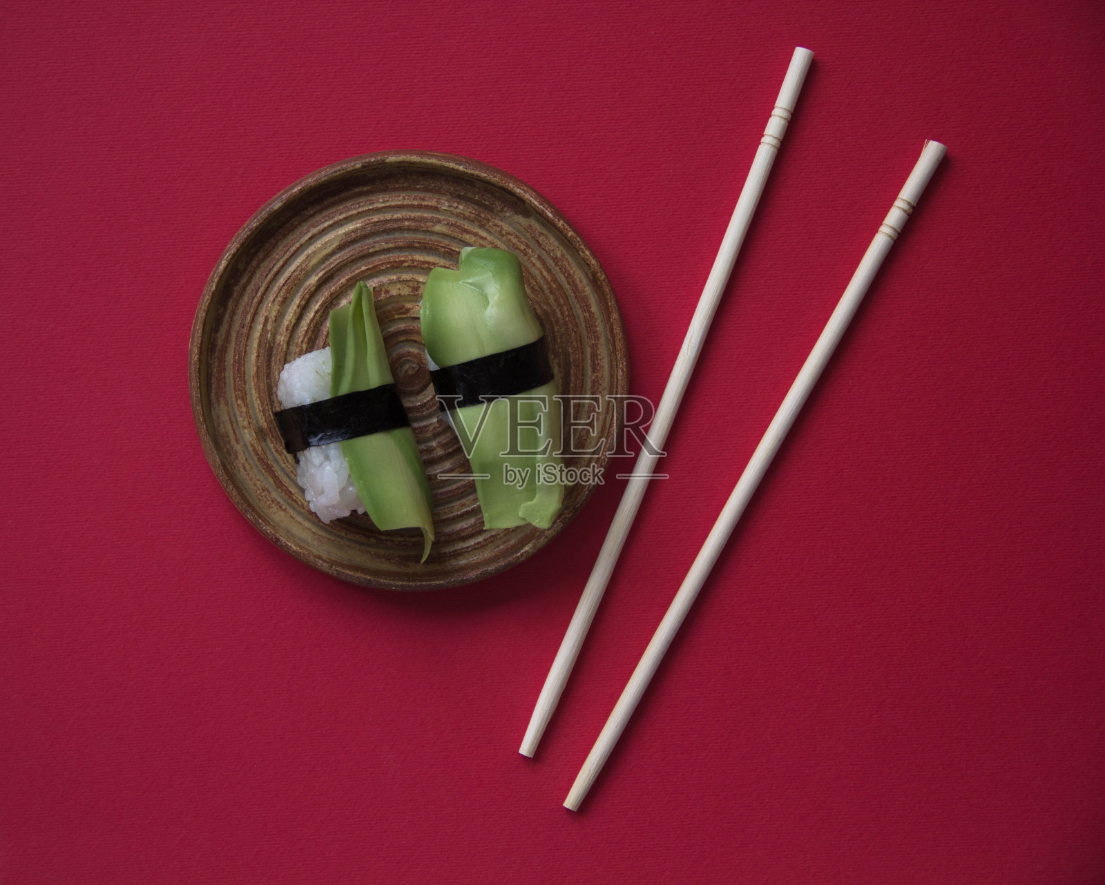 牛油果寿司孤立在红色背景，日本食物照片摄影图片