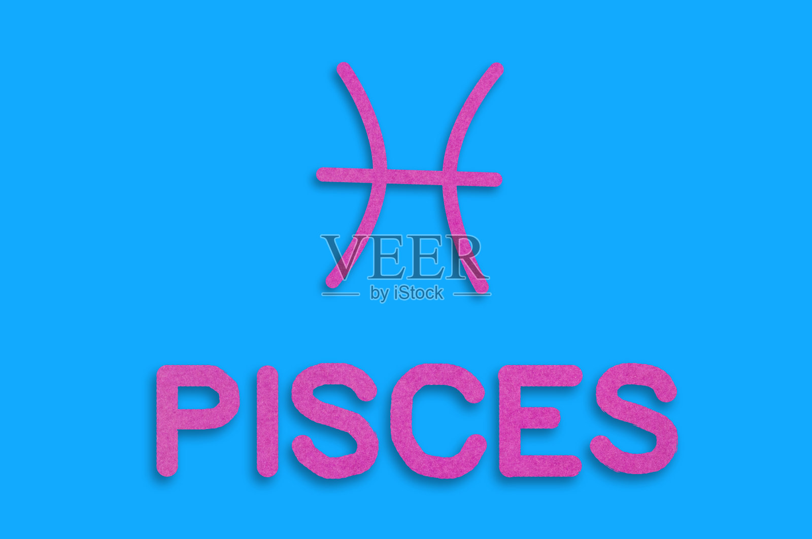 在蓝色的桌子上用紫色的纸剪出的星座符号和双鱼座的字。前视图。星座的概念照片摄影图片