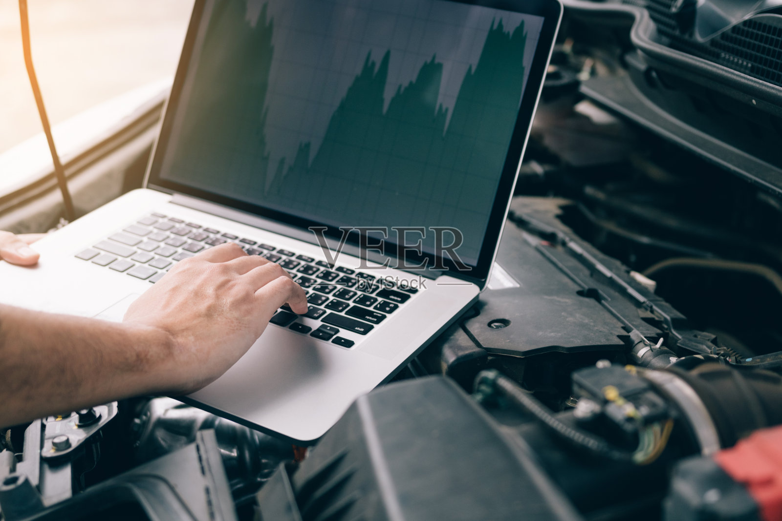 汽车维修技术人员使用笔记本电脑测量发动机值以进行分析。照片摄影图片