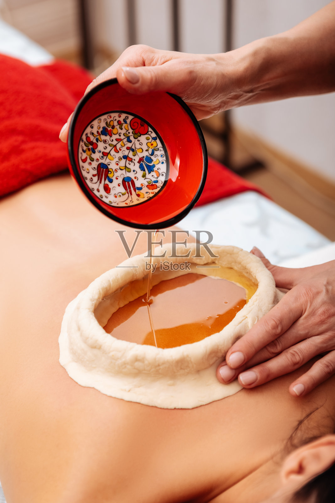 准确细心的工作人员仔细地将健康的油倒入盆中照片摄影图片