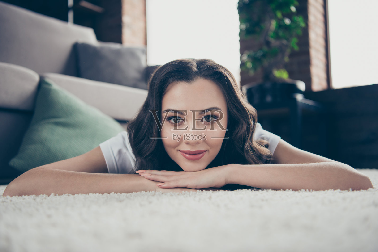 特写照片甜美美丽的黑发，她，她的夫人，家庭主妇躺在手臂上，沉思沉思，穿着家庭浅色的t恤，衣服，服装，地毯，地板，沙发照片摄影图片