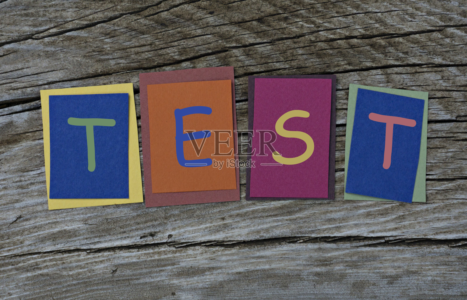 测试词写在彩色便利贴上木制背景。照片摄影图片