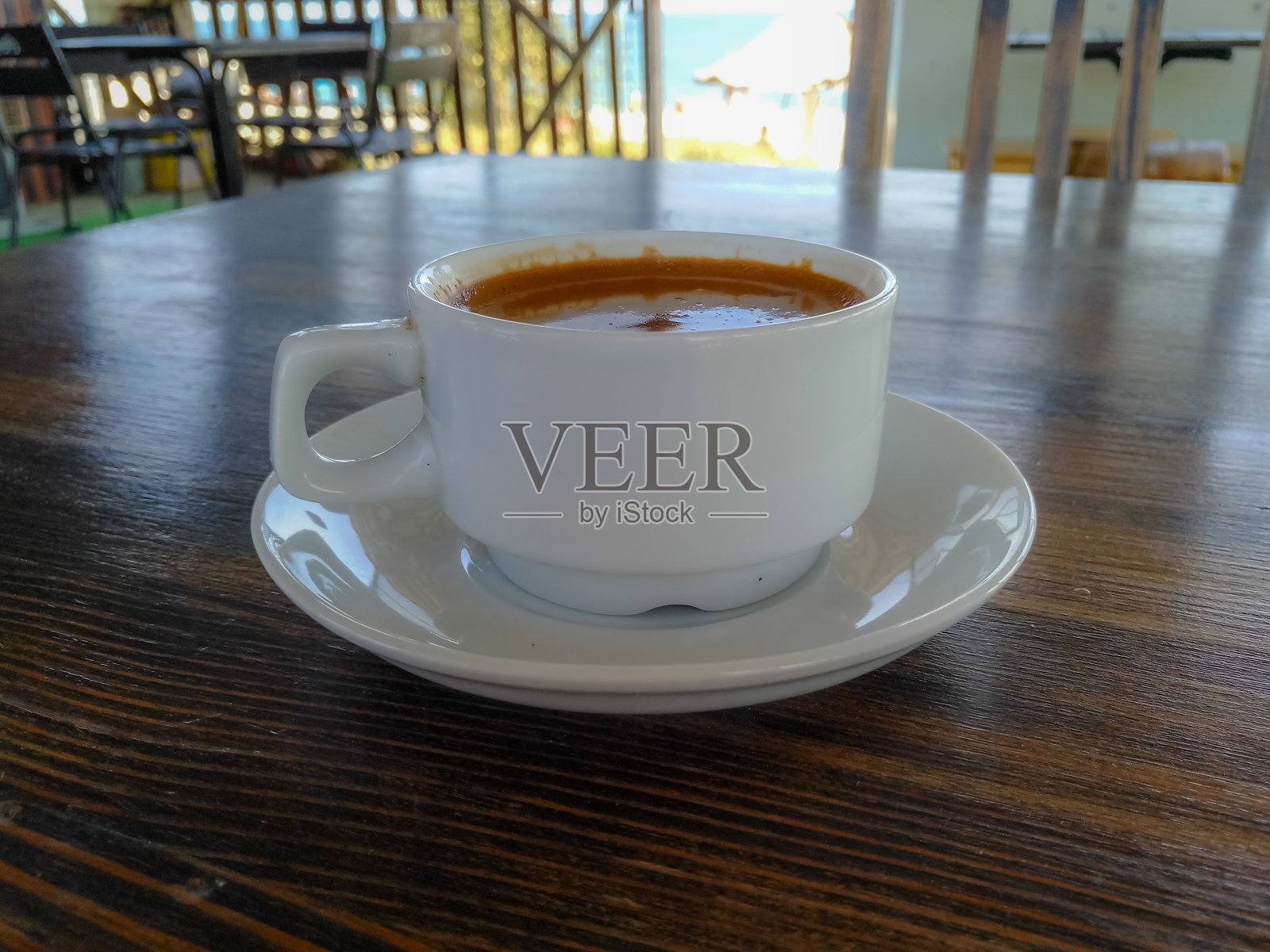 在海边咖啡馆的木桌上，一杯天然的黑咖啡照片摄影图片