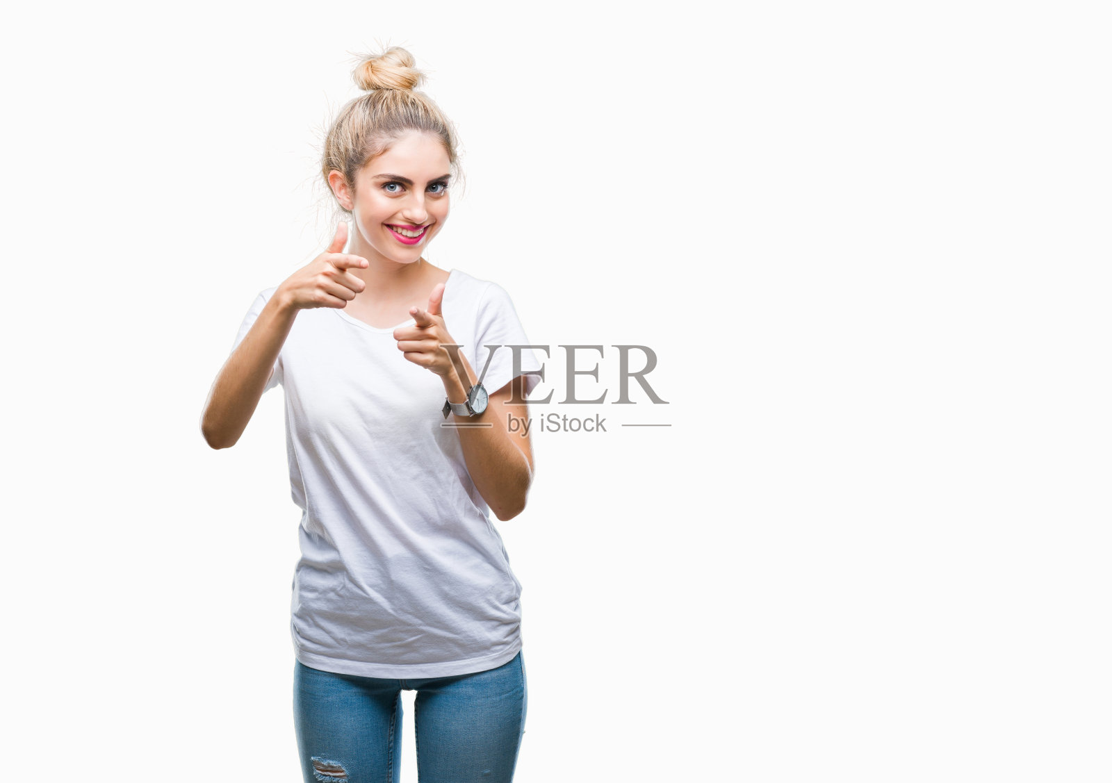 年轻美丽的金发女人穿着白色t恤在孤立的背景指向手指与快乐和有趣的脸相机。良好的能量和共鸣。照片摄影图片