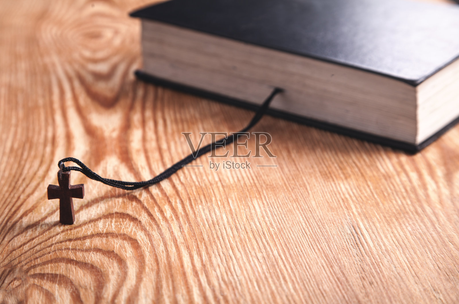 圣经和木制十字架放在木桌上。照片摄影图片