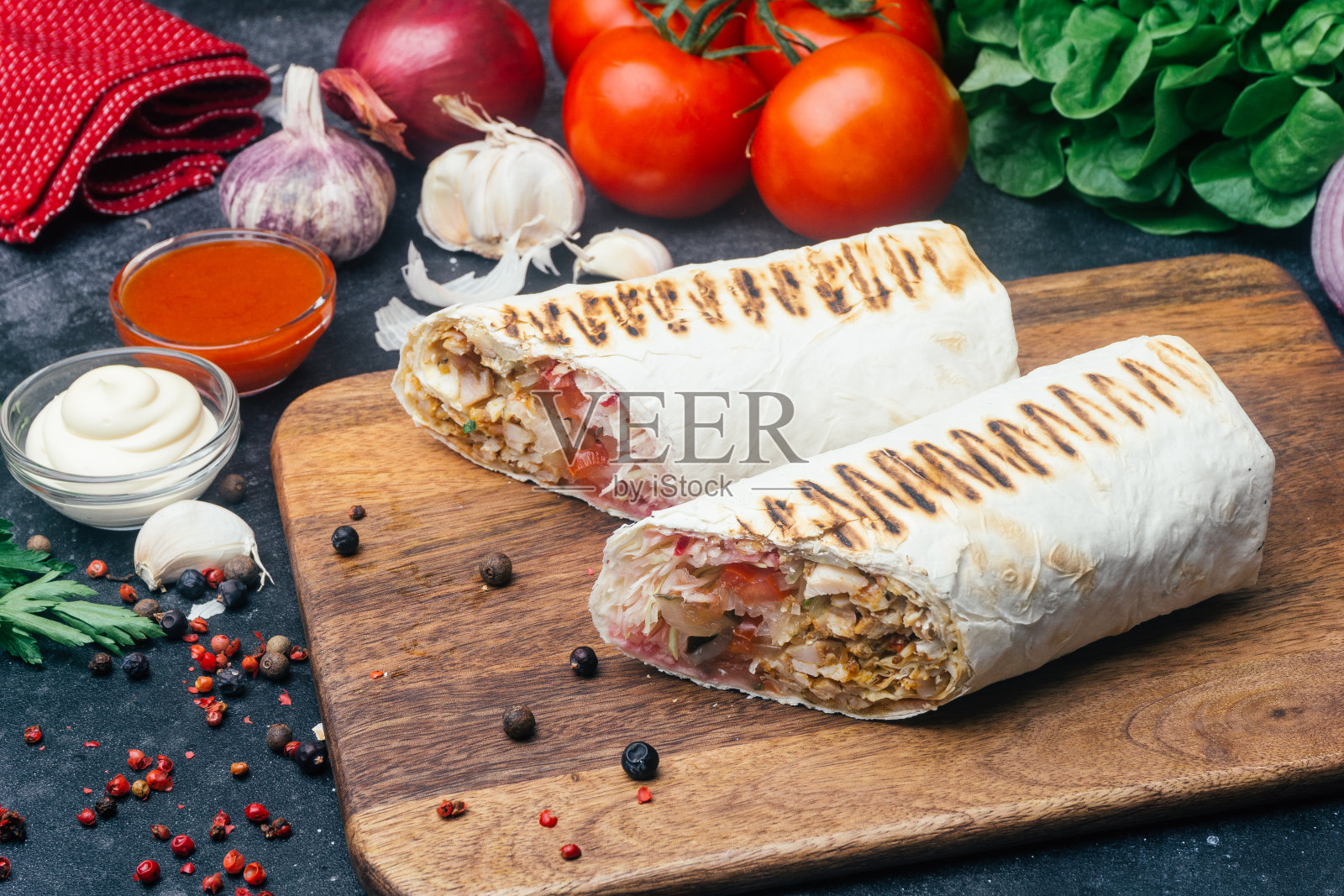 烤肉串(shawarma或Doner wrap)。烤鸡肉配新鲜蔬菜——西红柿、青菜沙拉、青椒。老木的背景。中东食品，阿拉伯快餐照片摄影图片