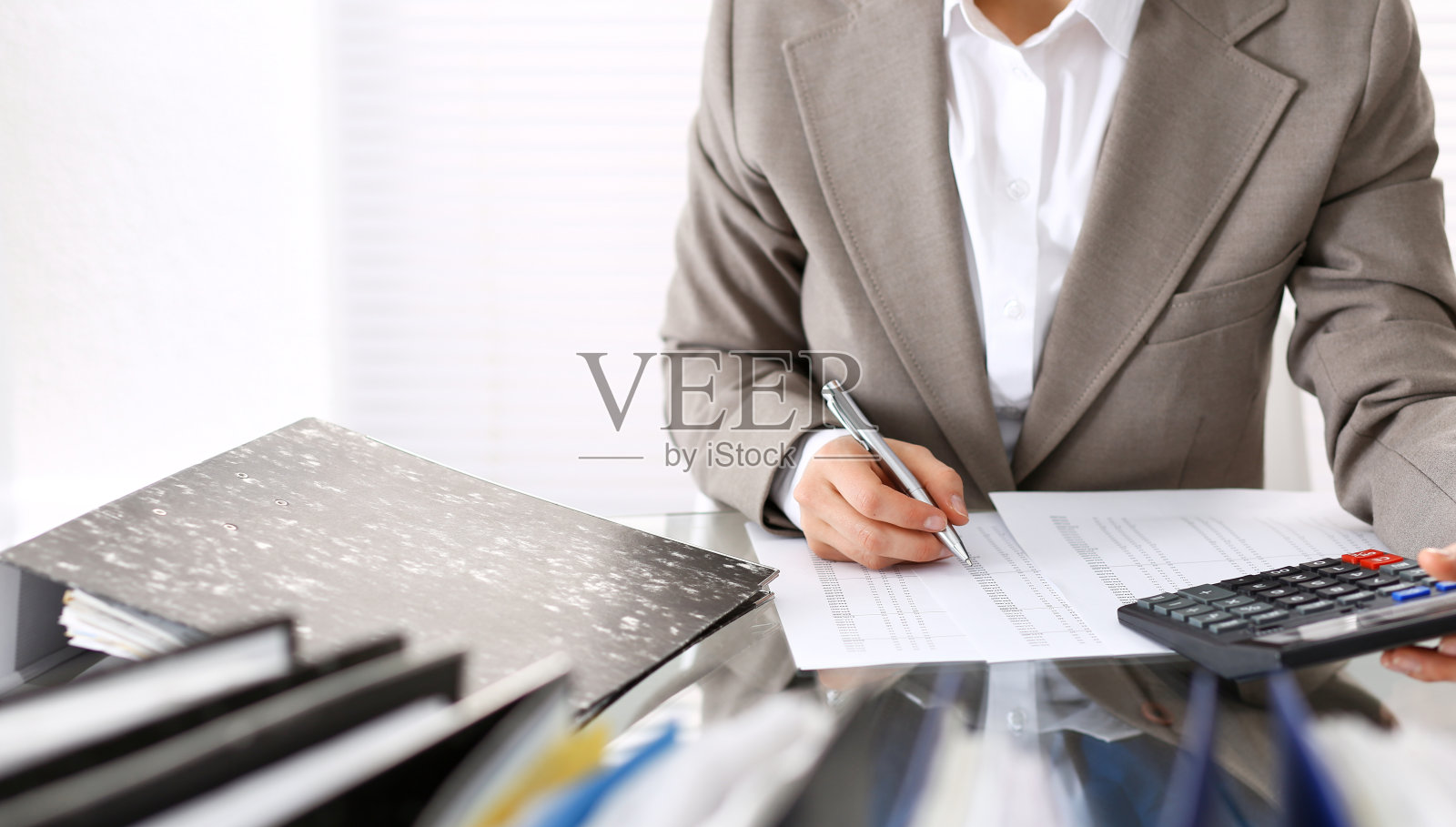 不知名的女簿记员或财务检查员作报告，计算或检查余额，特写。商业肖像。审计或税务概念照片摄影图片