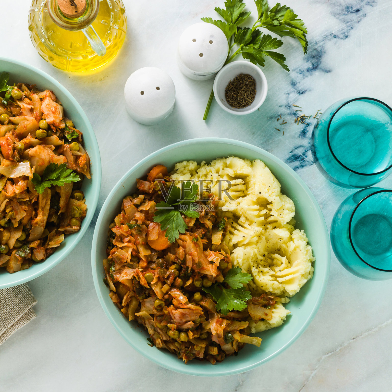 大理石桌上炖着卷心菜和蔬菜的土豆泥。健康的素食菜照片摄影图片