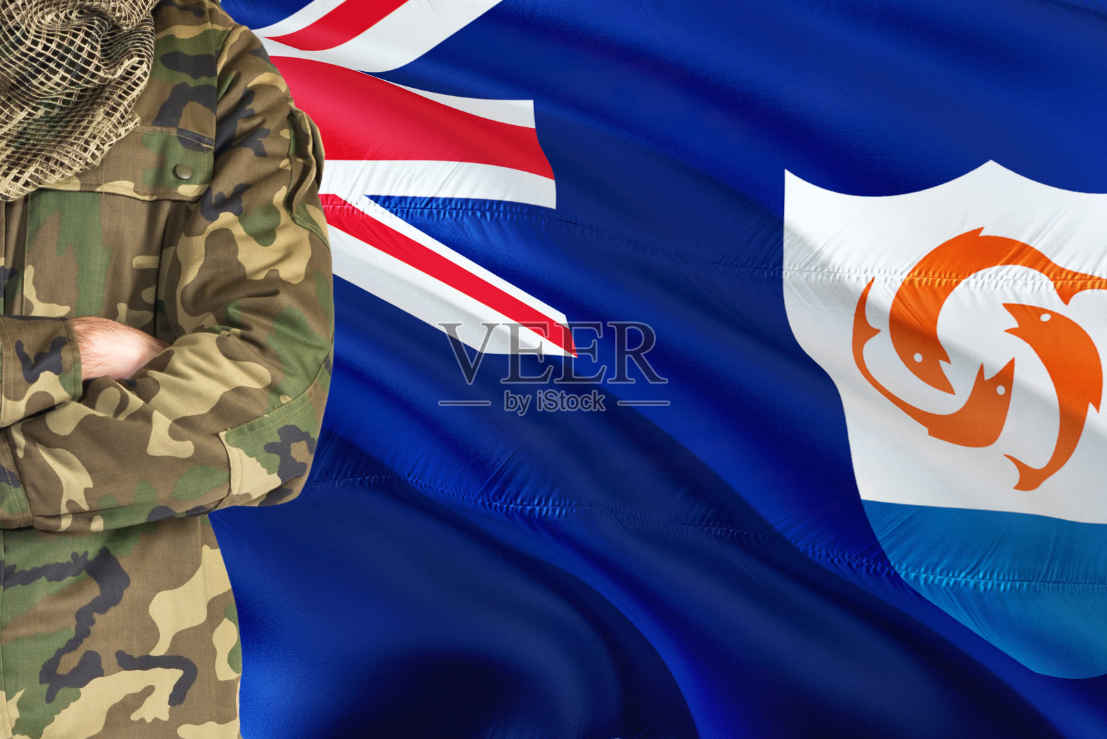 双臂交叉的安圭拉士兵以国旗为背景-安圭拉军事主题。照片摄影图片