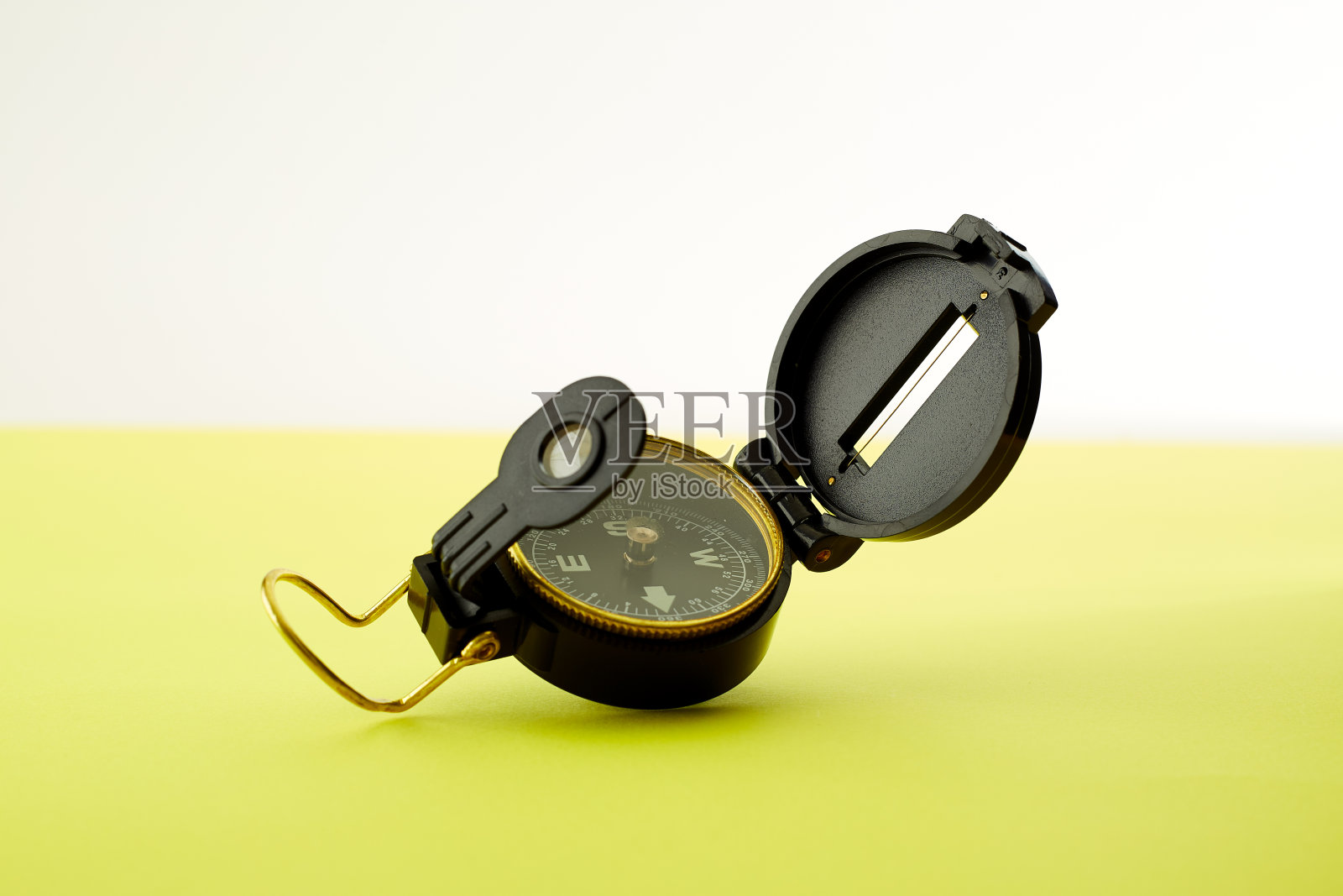明亮的黄色背景上的最小指南针，旅行的概念照片摄影图片