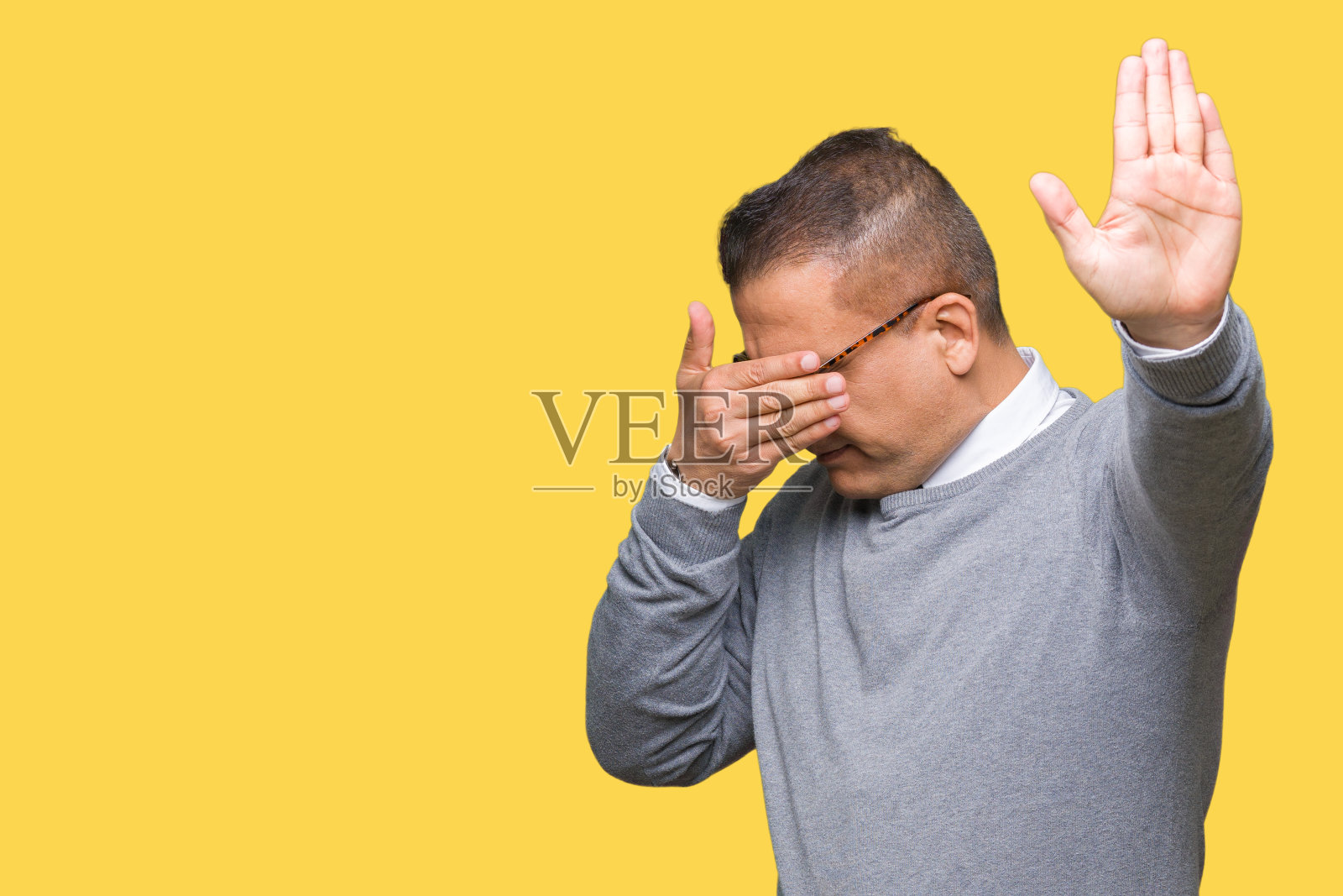 戴眼镜的中年阿拉伯商人用手捂住眼睛，做出停止的手势，表情悲伤和恐惧照片摄影图片