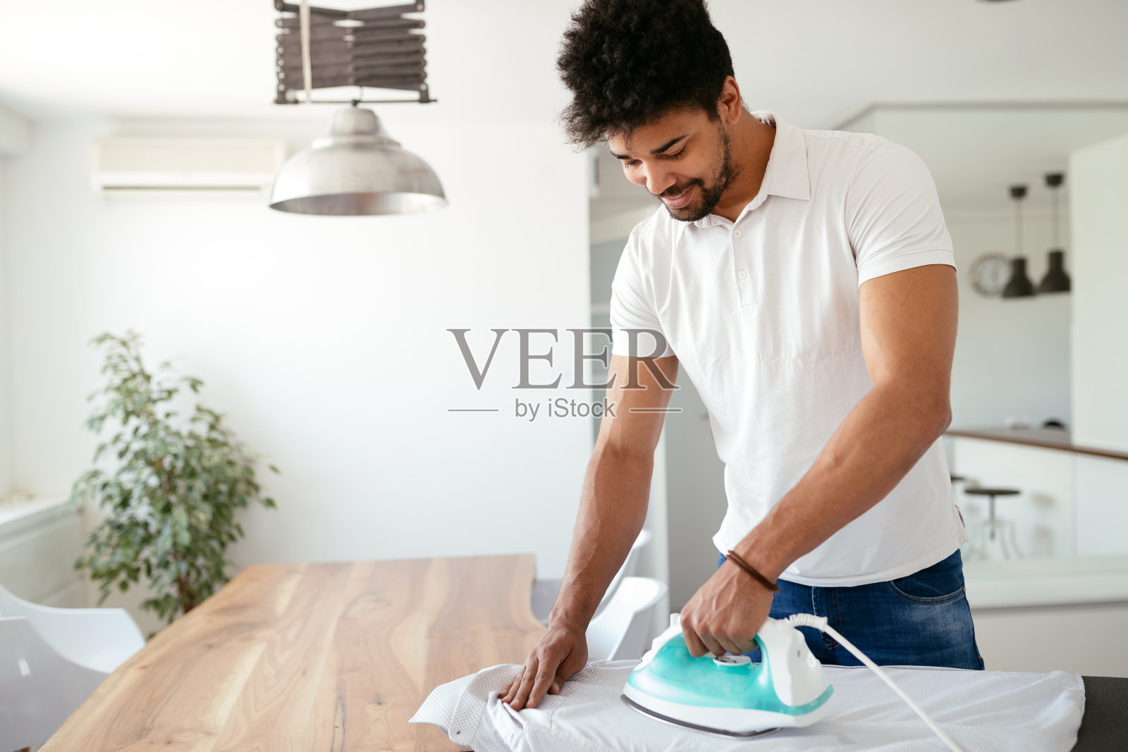 年轻快乐的男人熨衣服照片摄影图片