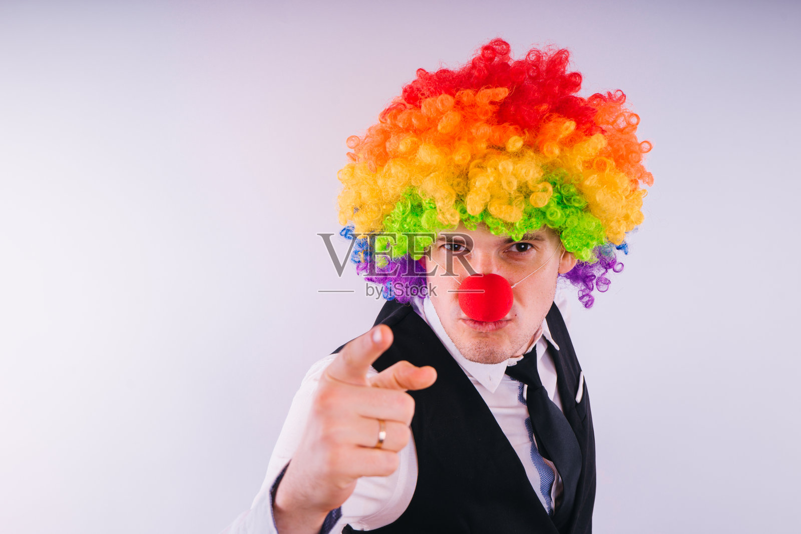 戴小丑假发的办公室职员，在工作中扮演小丑的角色。照片摄影图片