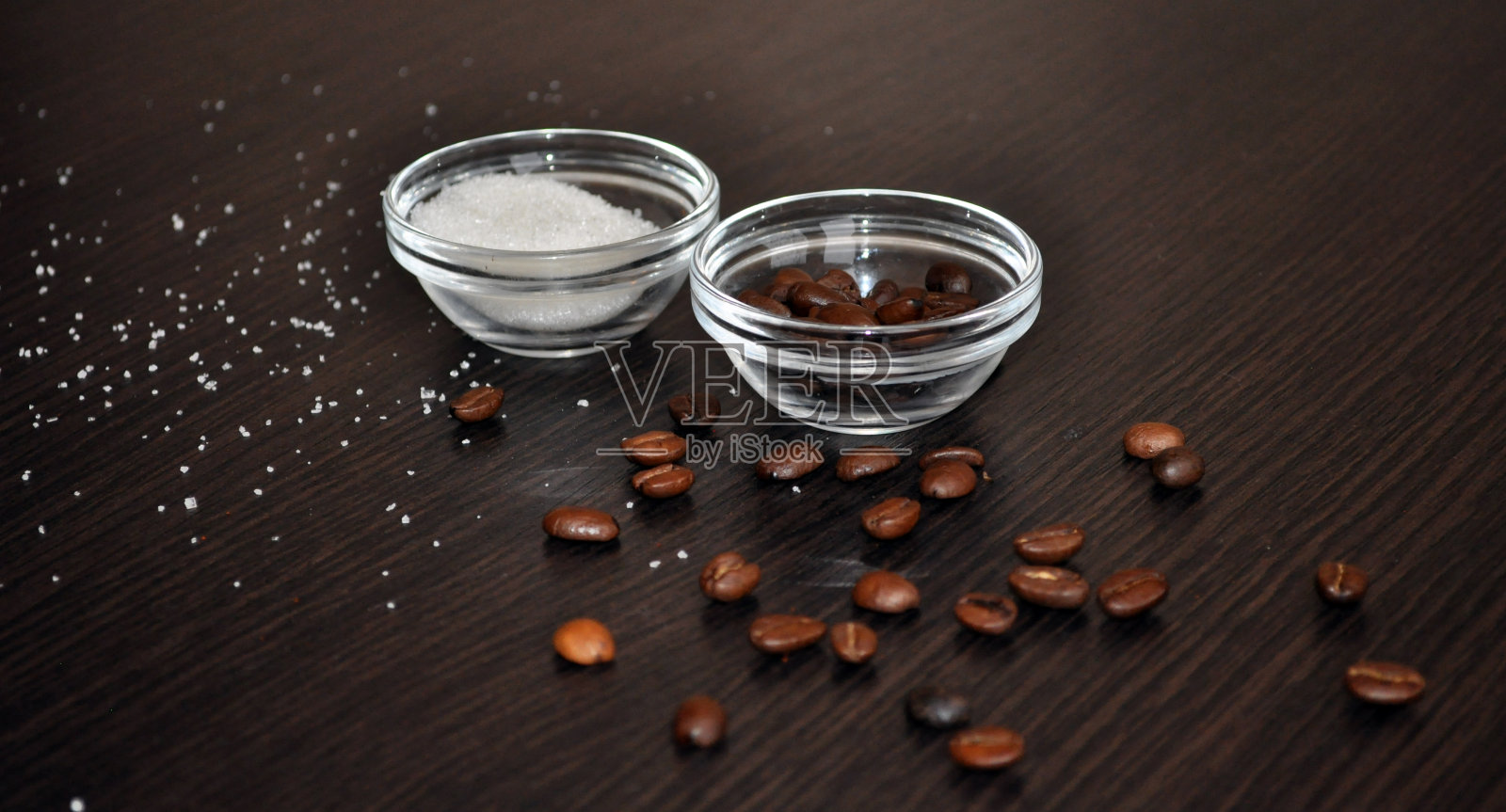 将咖啡豆和砂糖放在小玻璃盘子里照片摄影图片