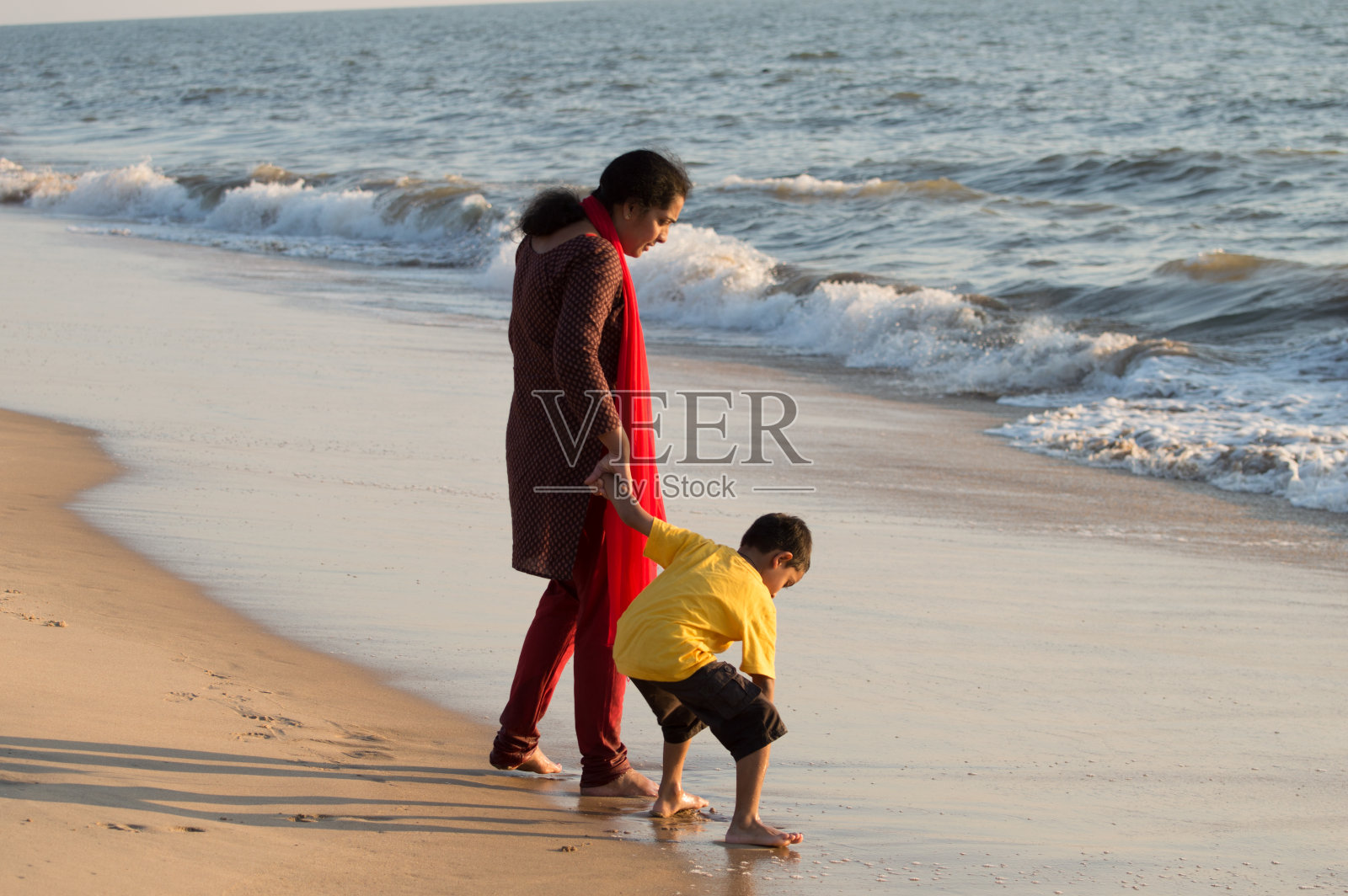 母亲和儿子在海滩上照片摄影图片
