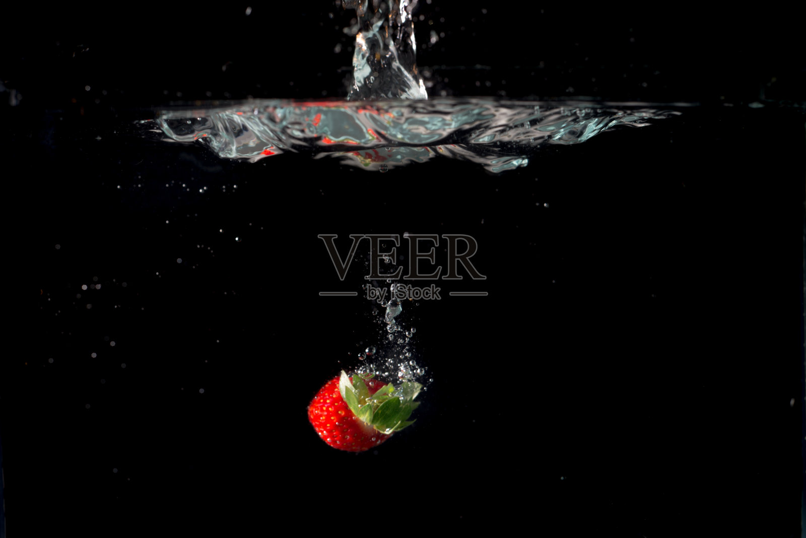新鲜草莓与水溅在黑色背景照片摄影图片