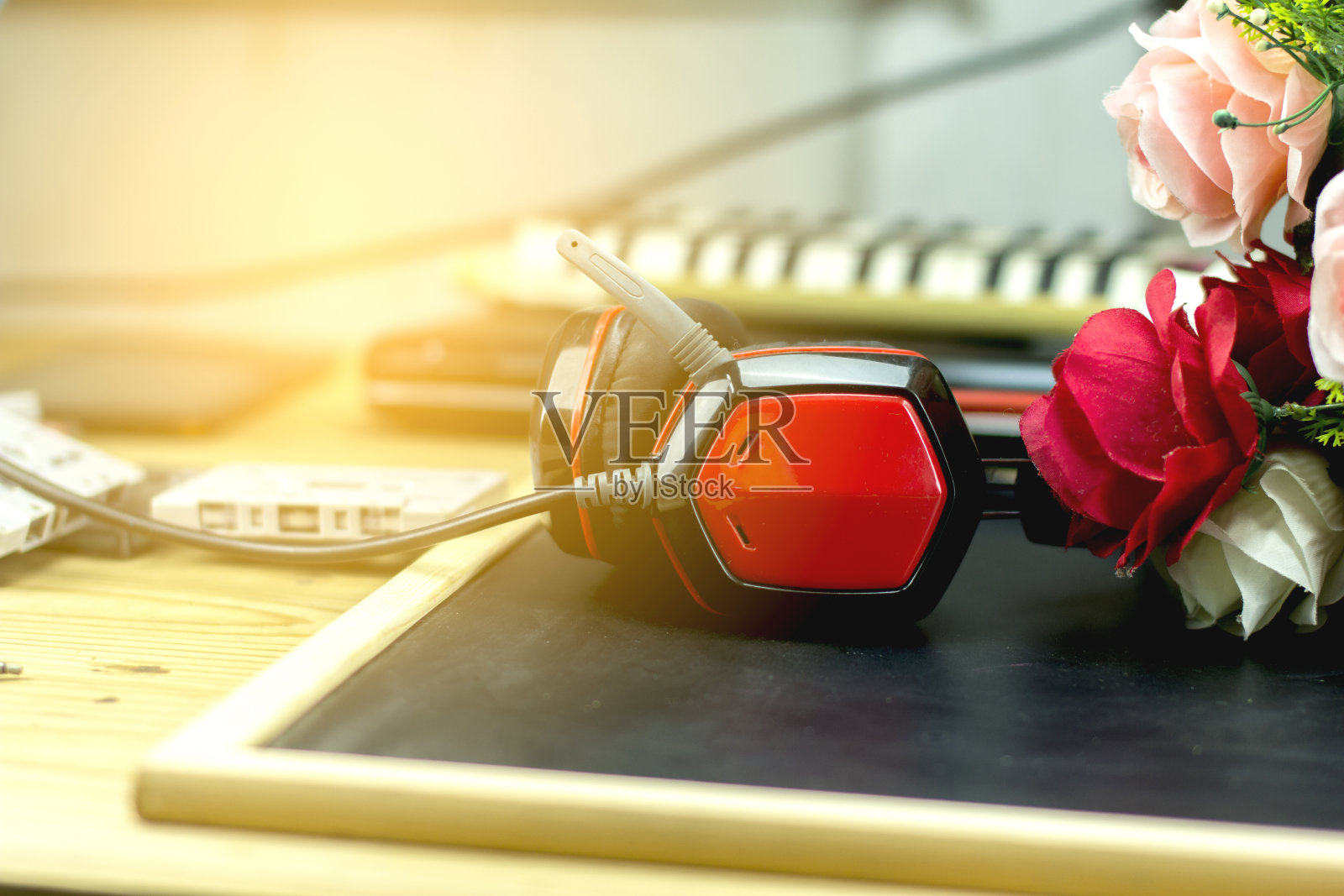 桌上放着红色耳机。照片摄影图片