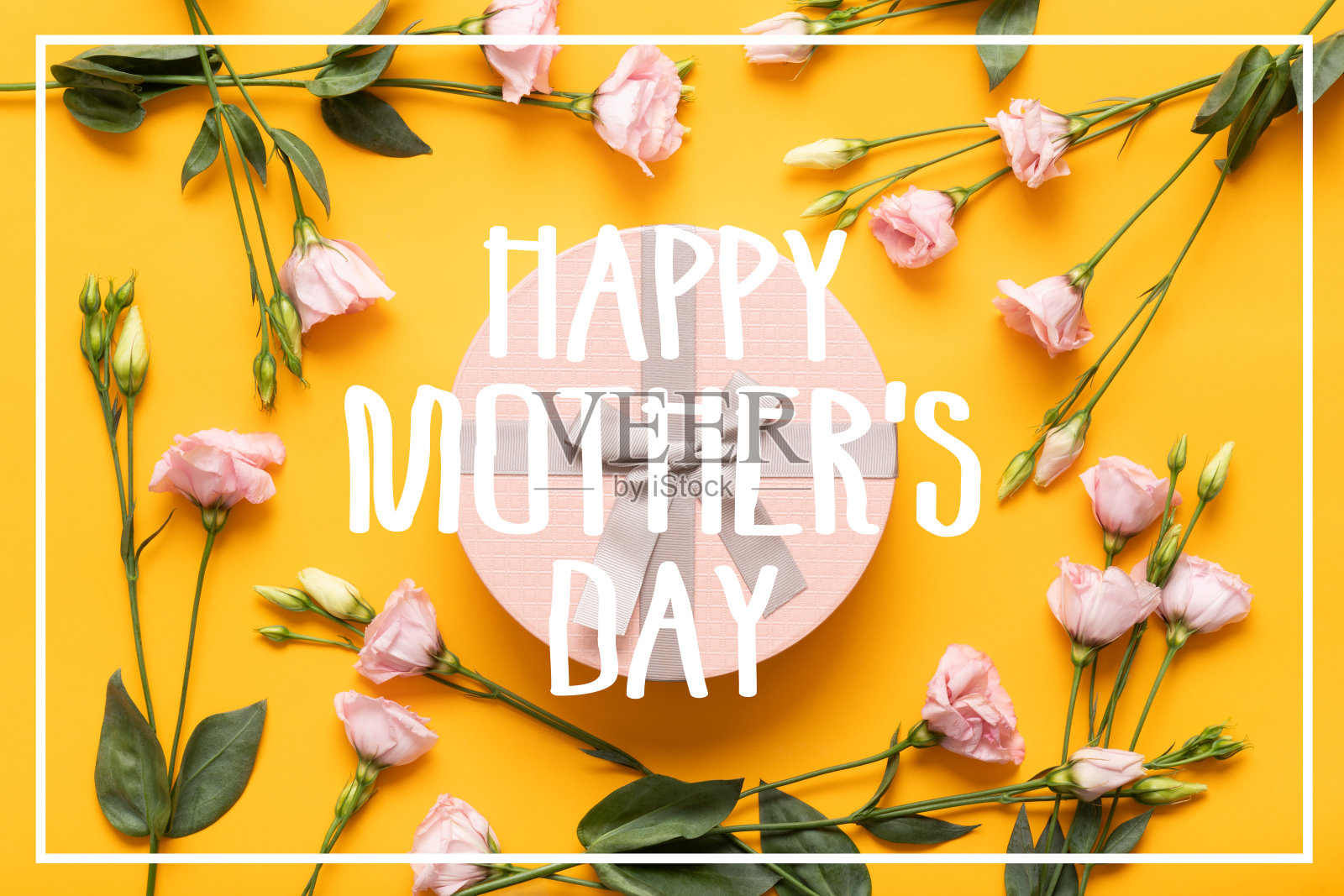 母亲节快乐。明亮的黄色和柔和的粉红色母亲节背景。扁平的贺卡与美丽的礼品盒和粉红色洋桔黄色花。照片摄影图片