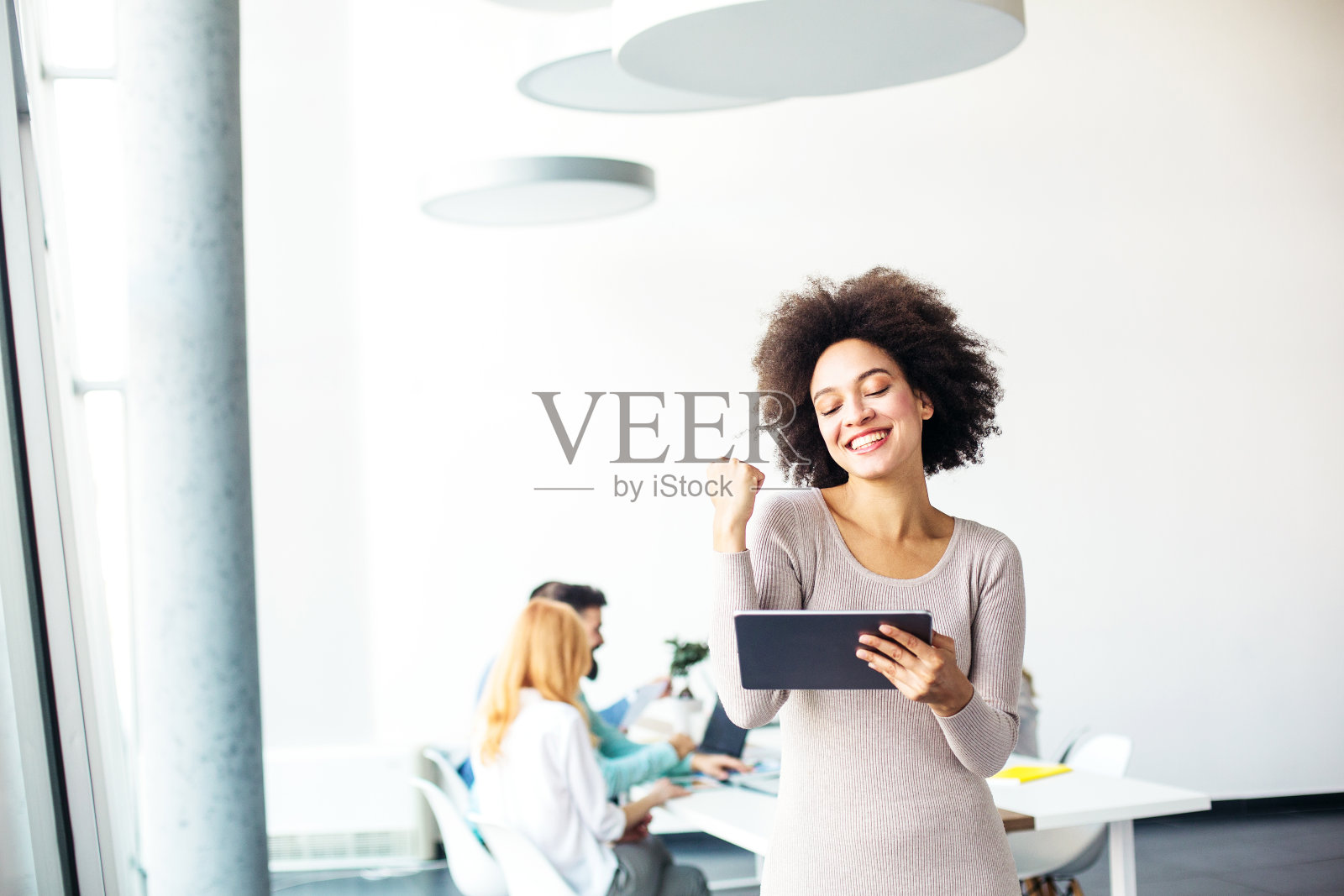 年轻的女商人在平板电脑上阅读好消息照片摄影图片