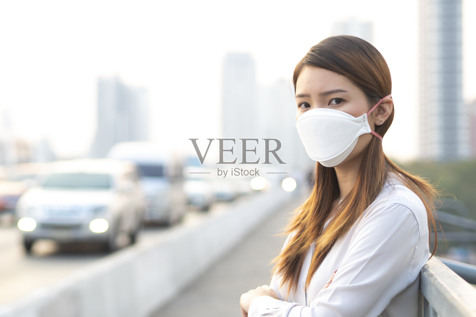 城市空气污染概念。近距离观察佩戴N95口罩的女性，保护城市pm2.5空气污染照片摄影图片