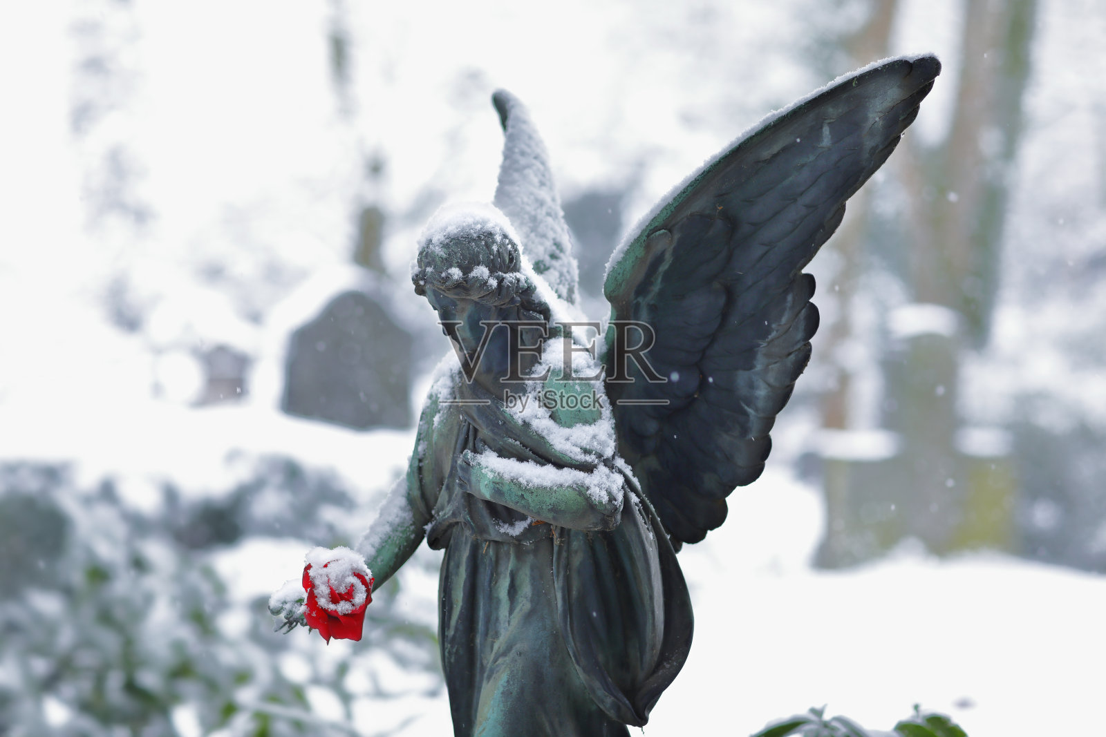 古色古香的天使雕像在深雪的墓地照片摄影图片