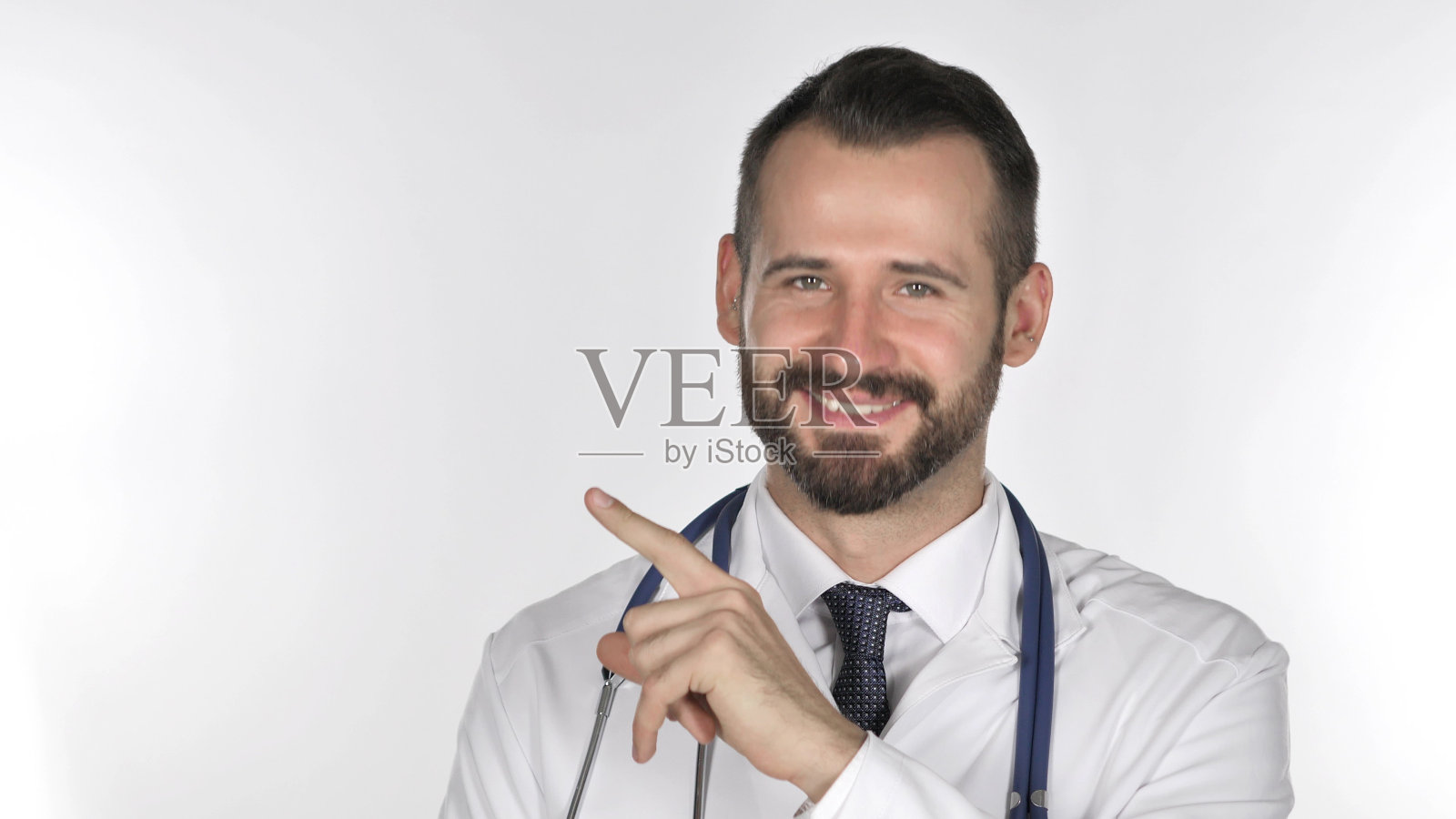 年轻胡子医生指着一边，白色背景照片摄影图片