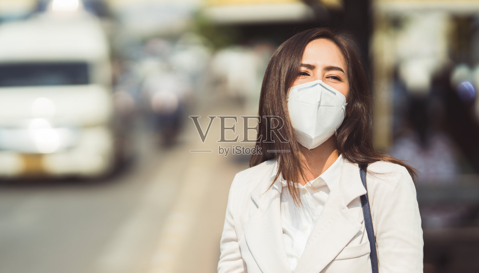 亚洲女性要去工作。她戴着N95口罩。防止PM2.5粉尘和雾霾照片摄影图片