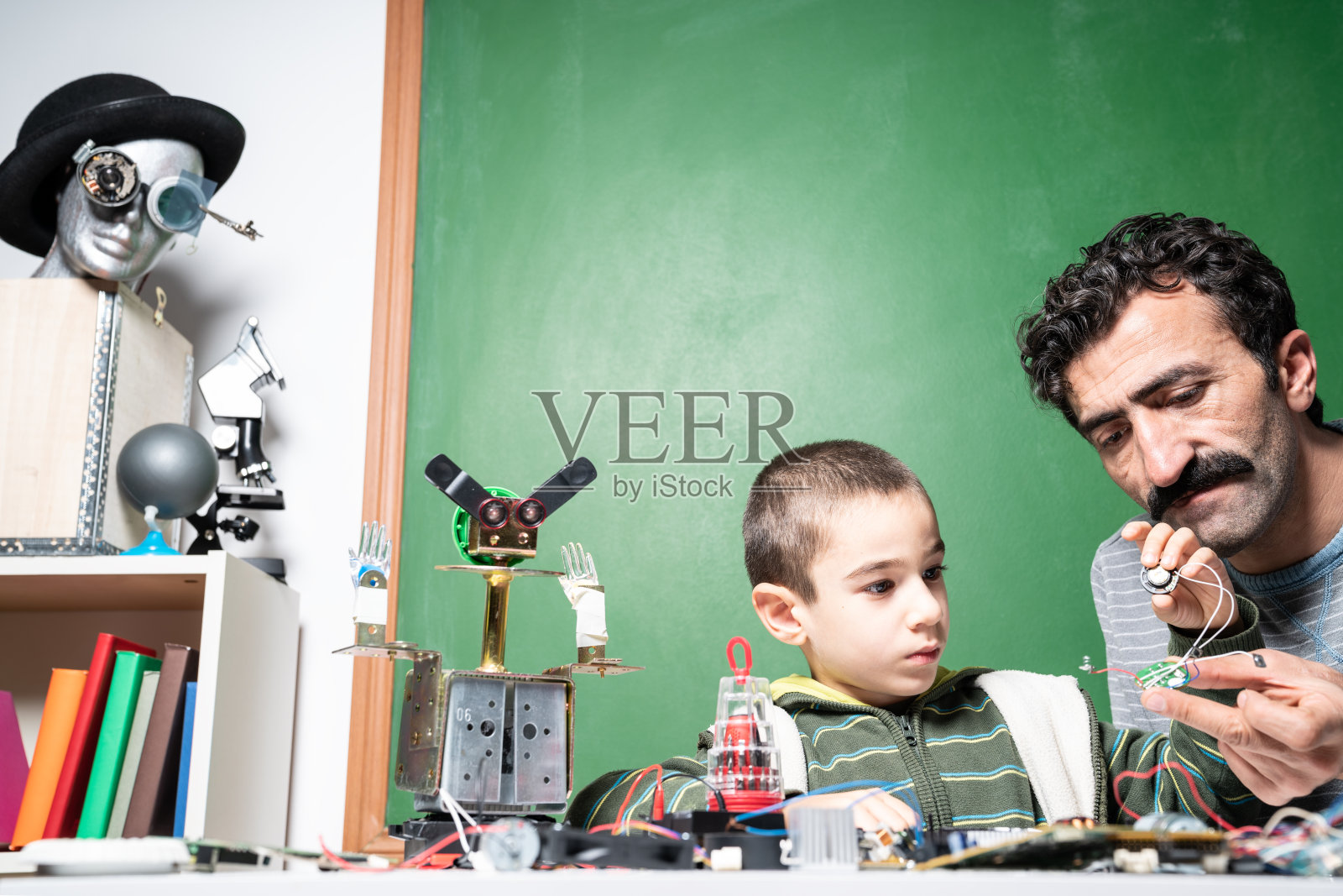 研究机器人的小男孩和老师照片摄影图片