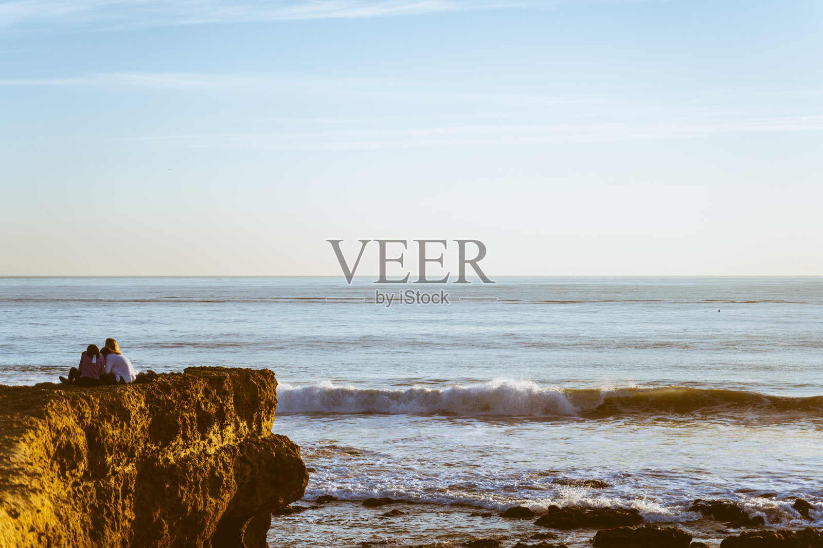 两个人在日落时望向大海，海滩，葡萄牙的carcavvelos照片摄影图片