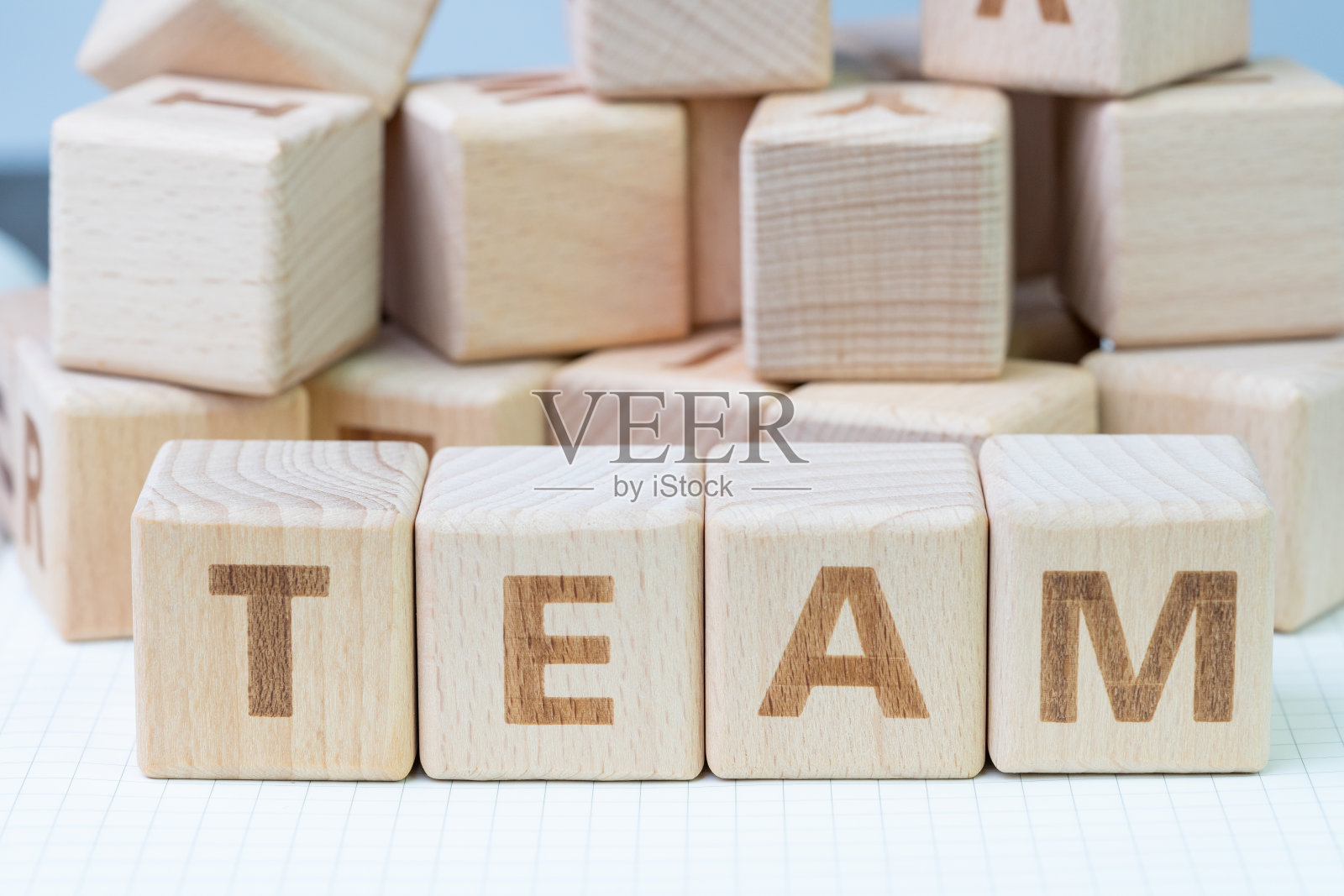 团队合作的概念，木制立方体块与字母形成的单词团队在白色网格线笔记本，一起工作的力量，以成功完成的事情照片摄影图片