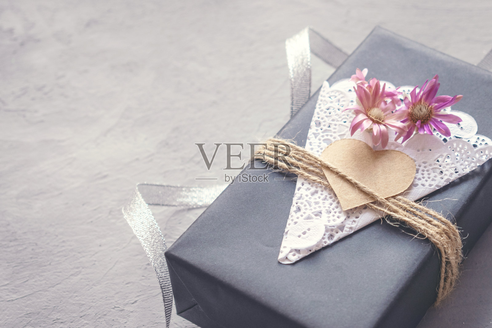 情人节，生日工艺礼盒与装饰的黑色纸礼物盒心，花边餐巾，黄麻绳在灰色水泥背景。爱，浪漫，手工的概念照片摄影图片