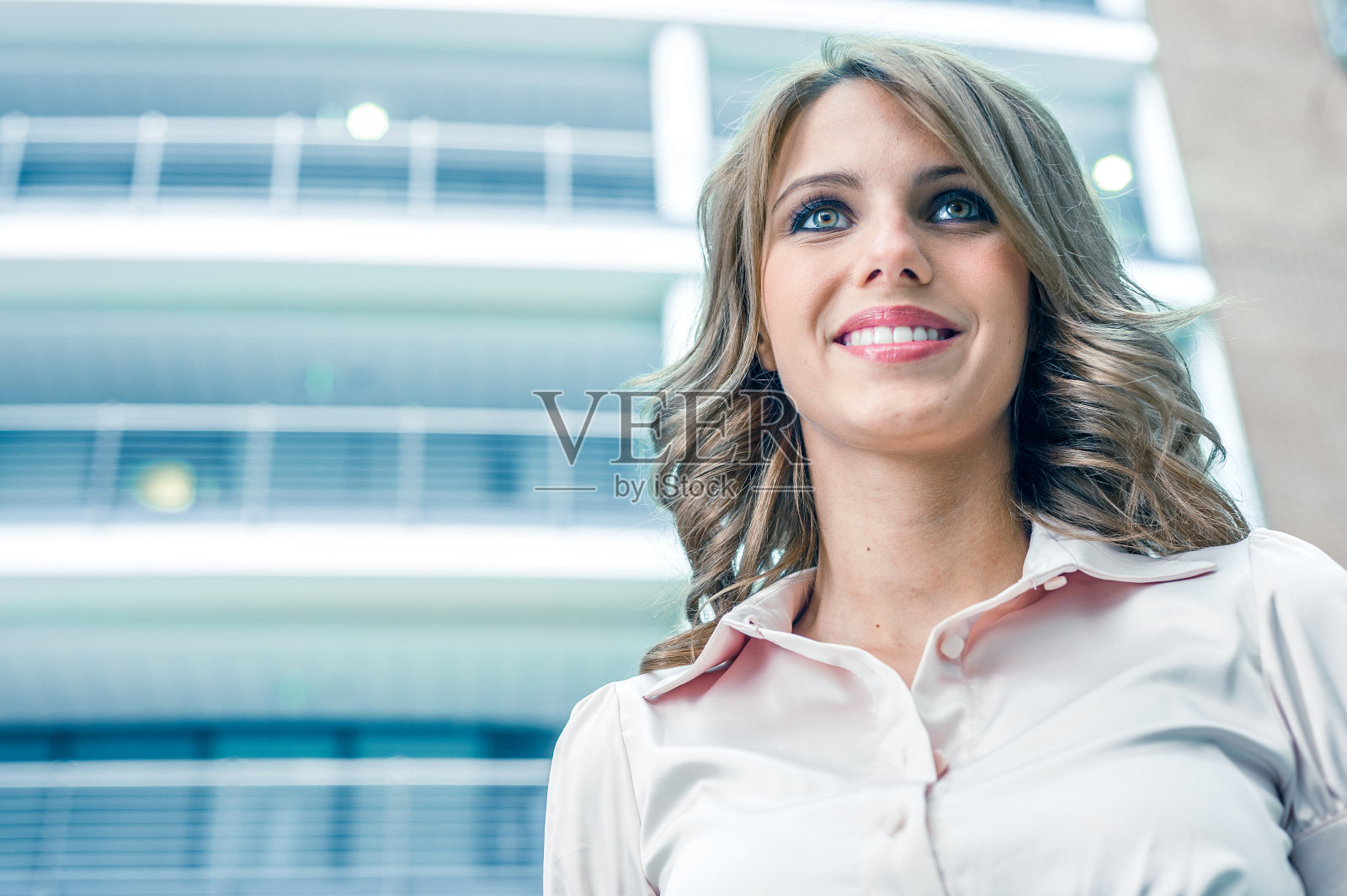 年轻的女商人站在办公室里照片摄影图片