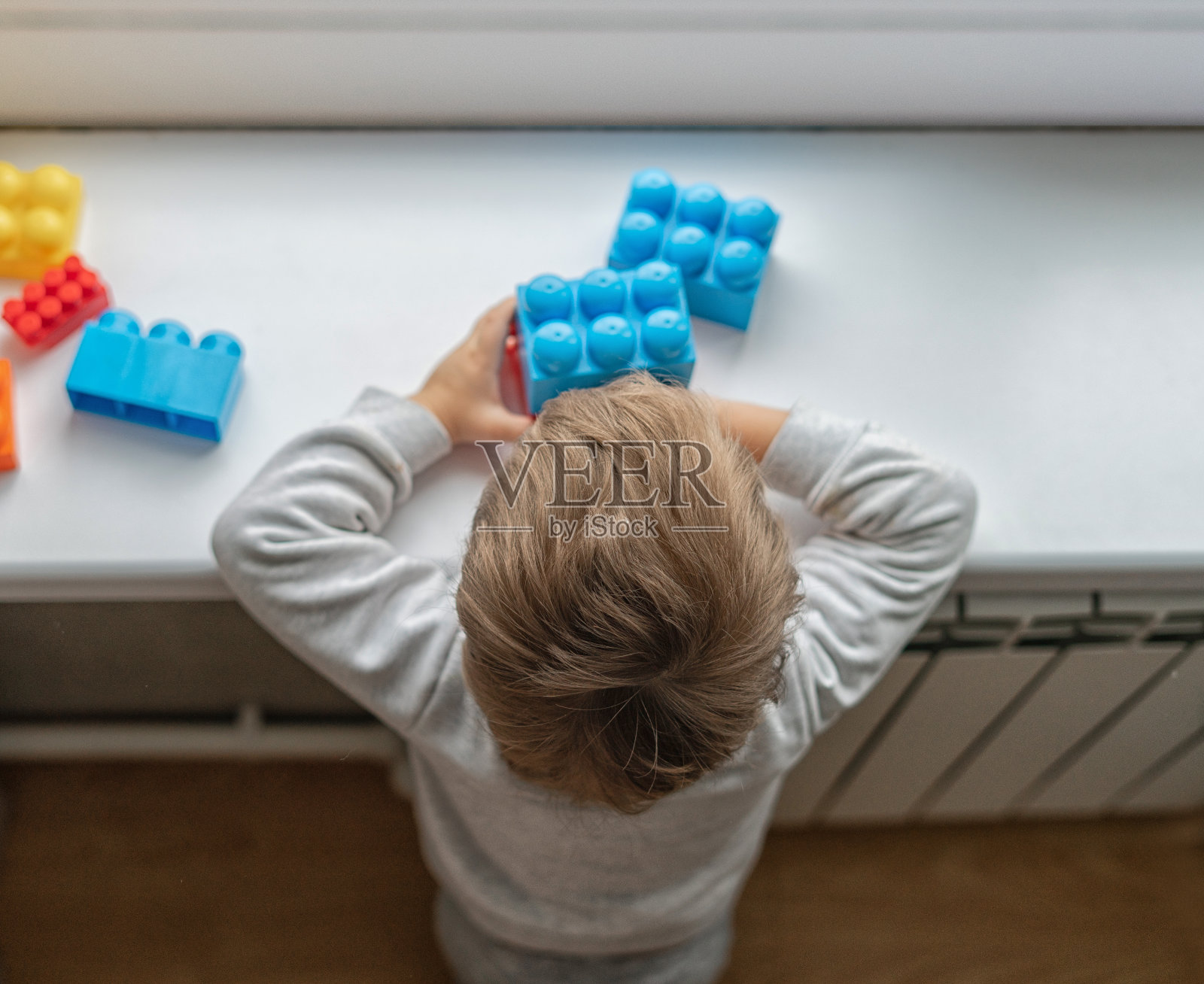 孩子在玩五颜六色的积木。小男孩在家里或日托所建塔。儿童教育玩具。婴儿或蹒跚学步的孩子的积木照片摄影图片