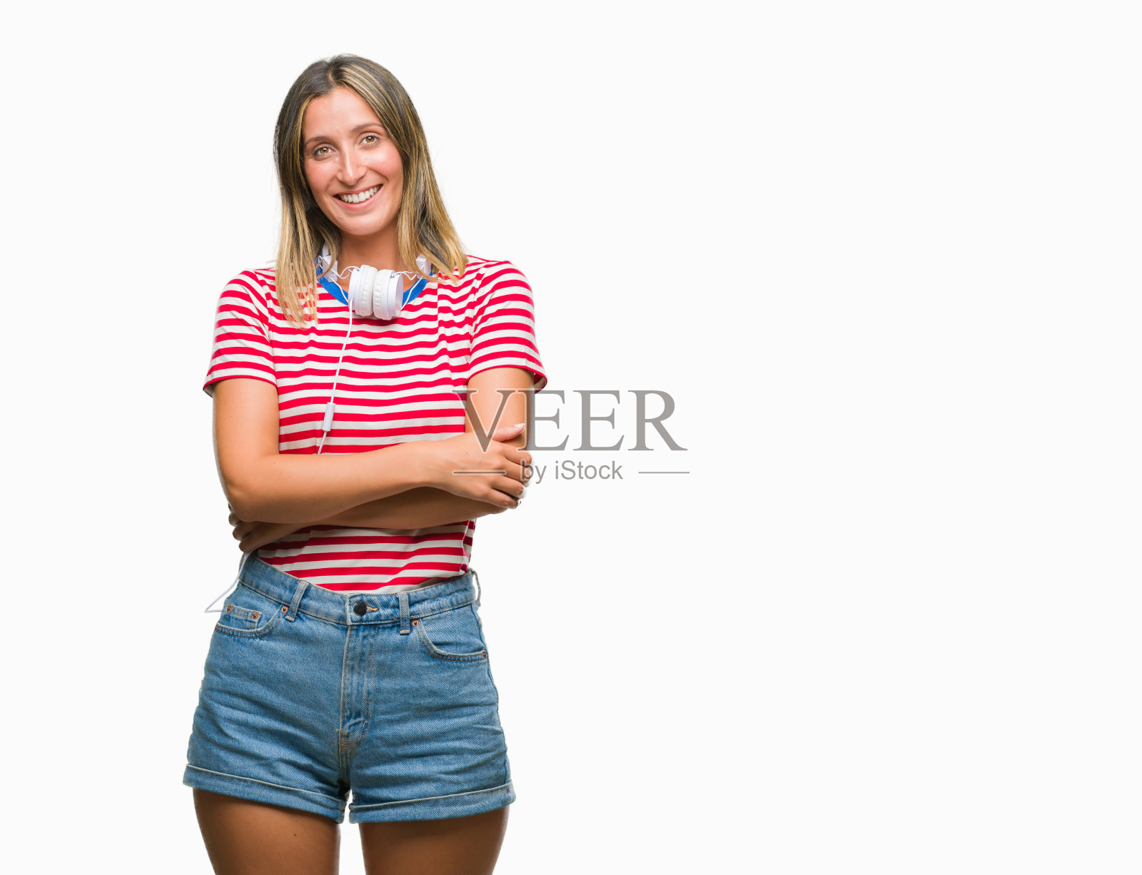 年轻美丽的女人听音乐戴着耳机在孤立的背景快乐的脸微笑，双臂交叉看着相机。积极的人。照片摄影图片