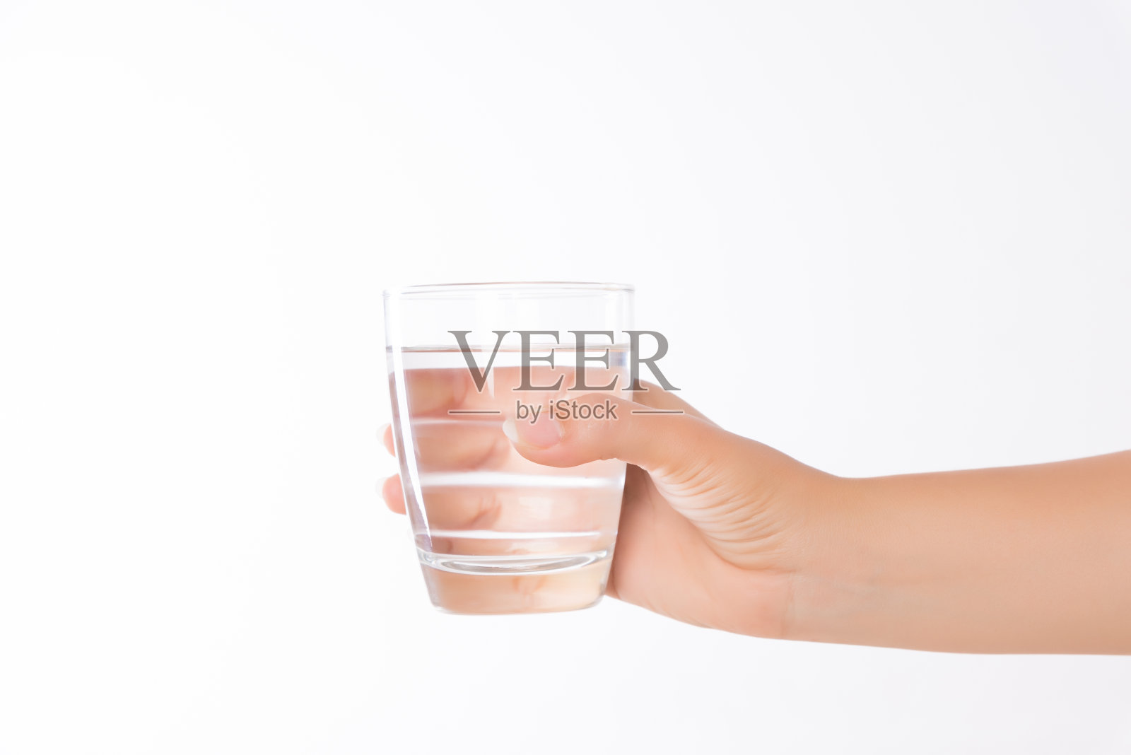 女人手里拿着一杯干净的矿泉水。环保、健康饮品、保健理念。照片摄影图片