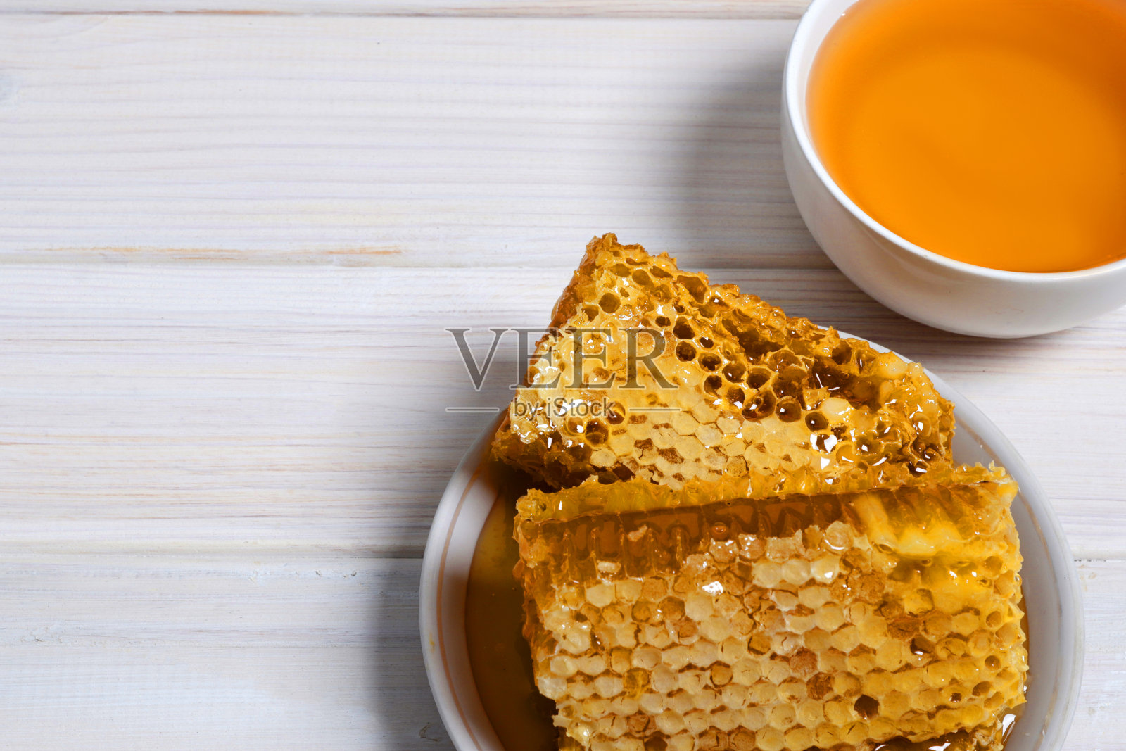 传统医学。蜂蜜和蜂房。木桌上放着姜和柠檬。文本。前视图。照片摄影图片