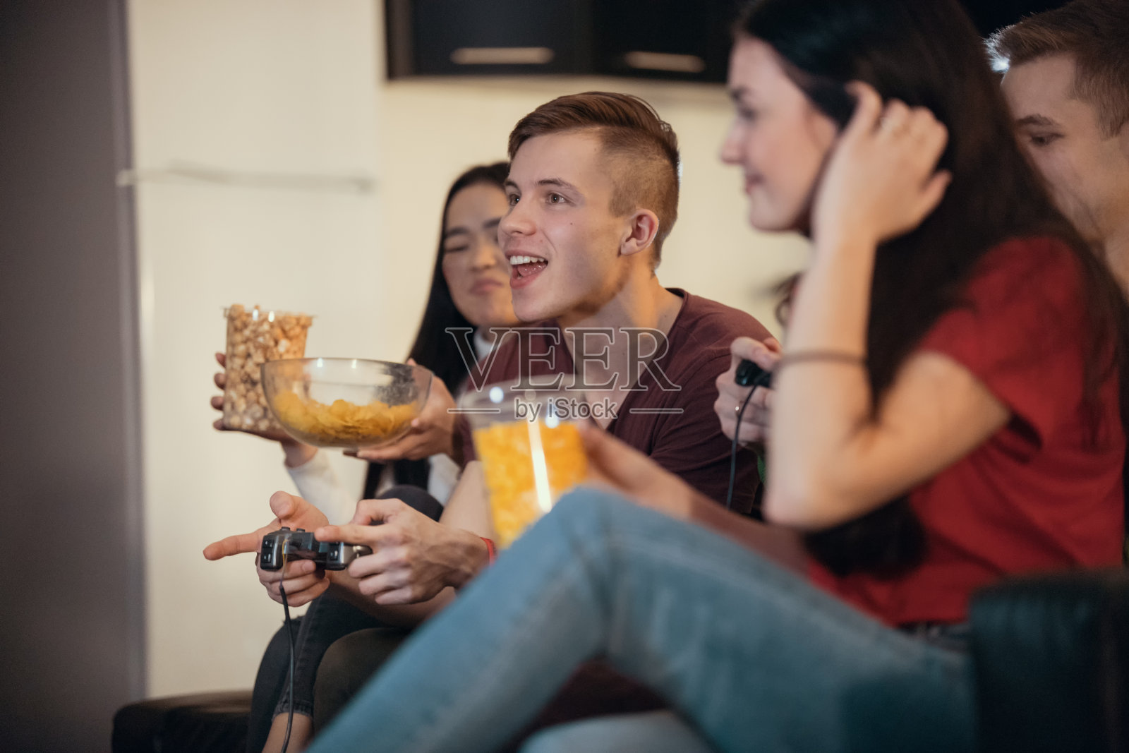 陪伴年轻的朋友一起玩游戏和吃东西照片摄影图片