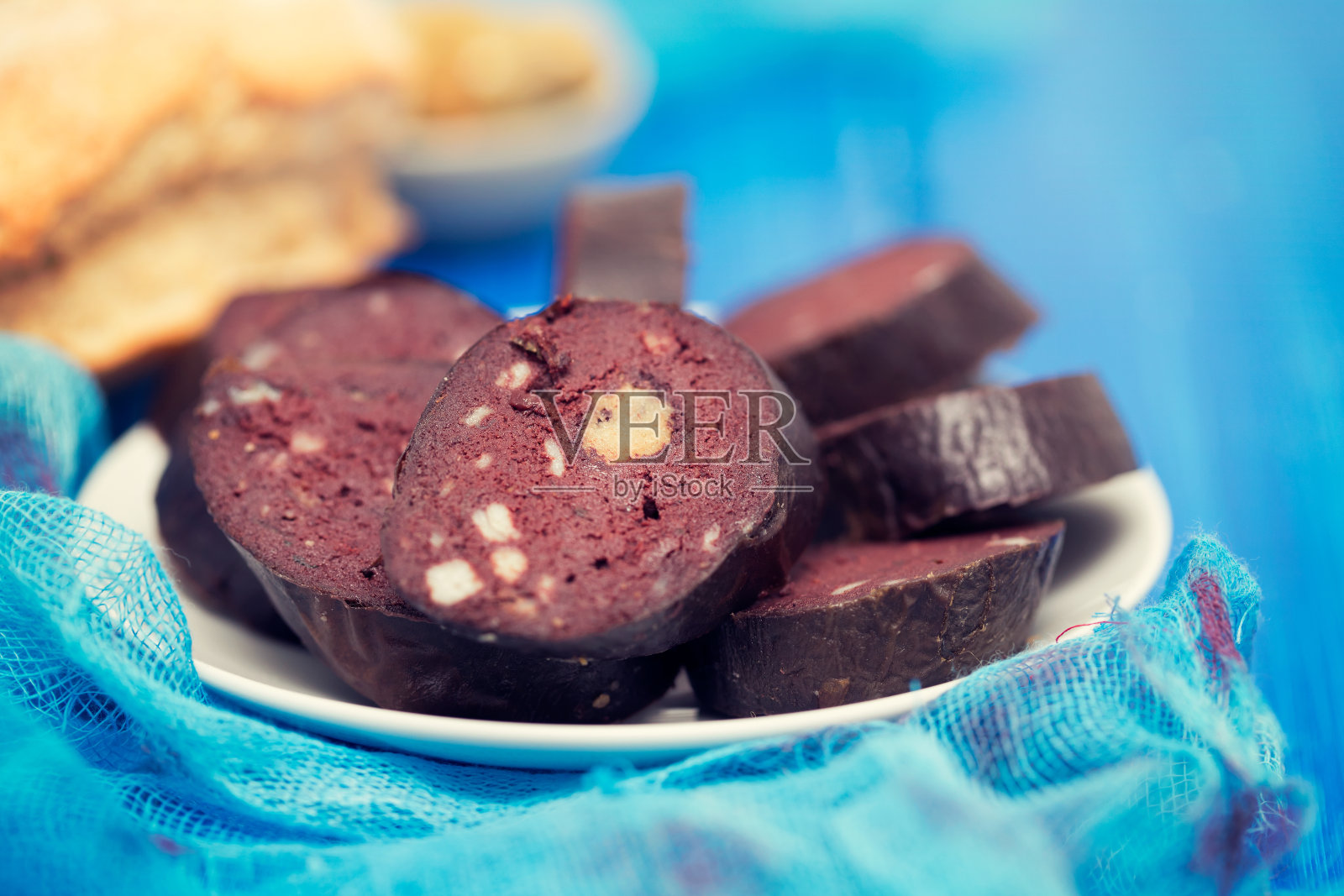 蓝底白盘子上的葡萄牙血肠照片摄影图片