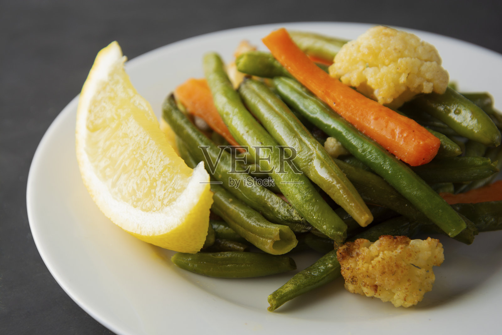 素食。用红豆、胡萝卜和柠檬煮熟，放在白盘子里。著名的中国菜。健康食品。照片摄影图片