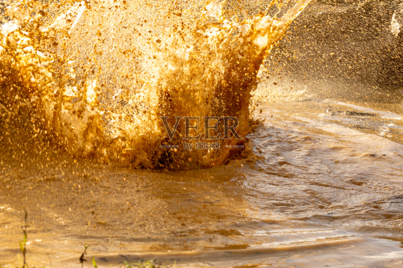 在障碍赛的水坑溅起的水滴和泥的细节。照片摄影图片