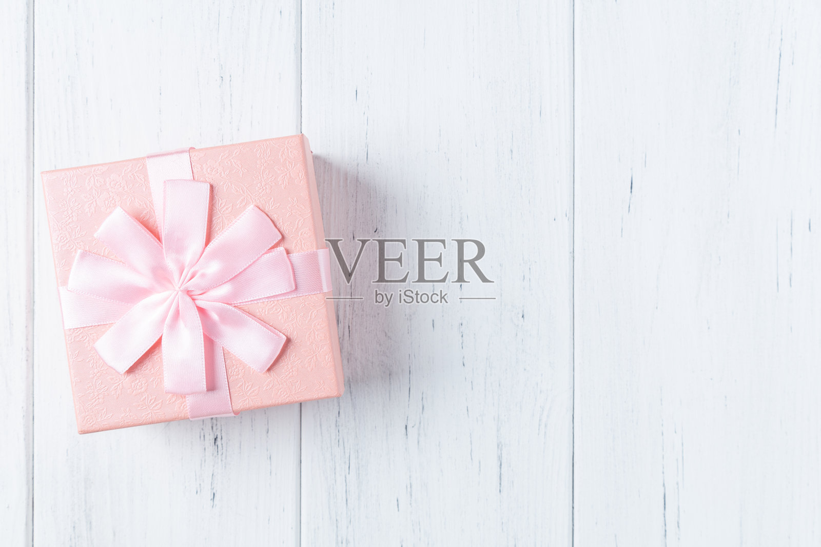 装饰粉色礼盒与蝴蝶结在木桌上照片摄影图片