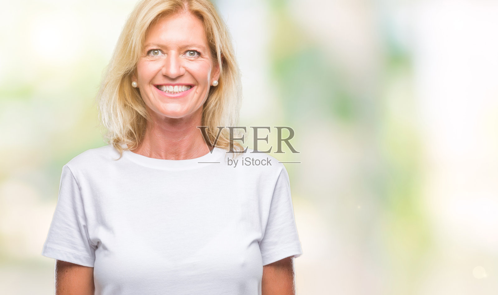 中年金发女子在孤立的背景下，脸上带着幸福和凉爽的微笑。幸运的人。照片摄影图片