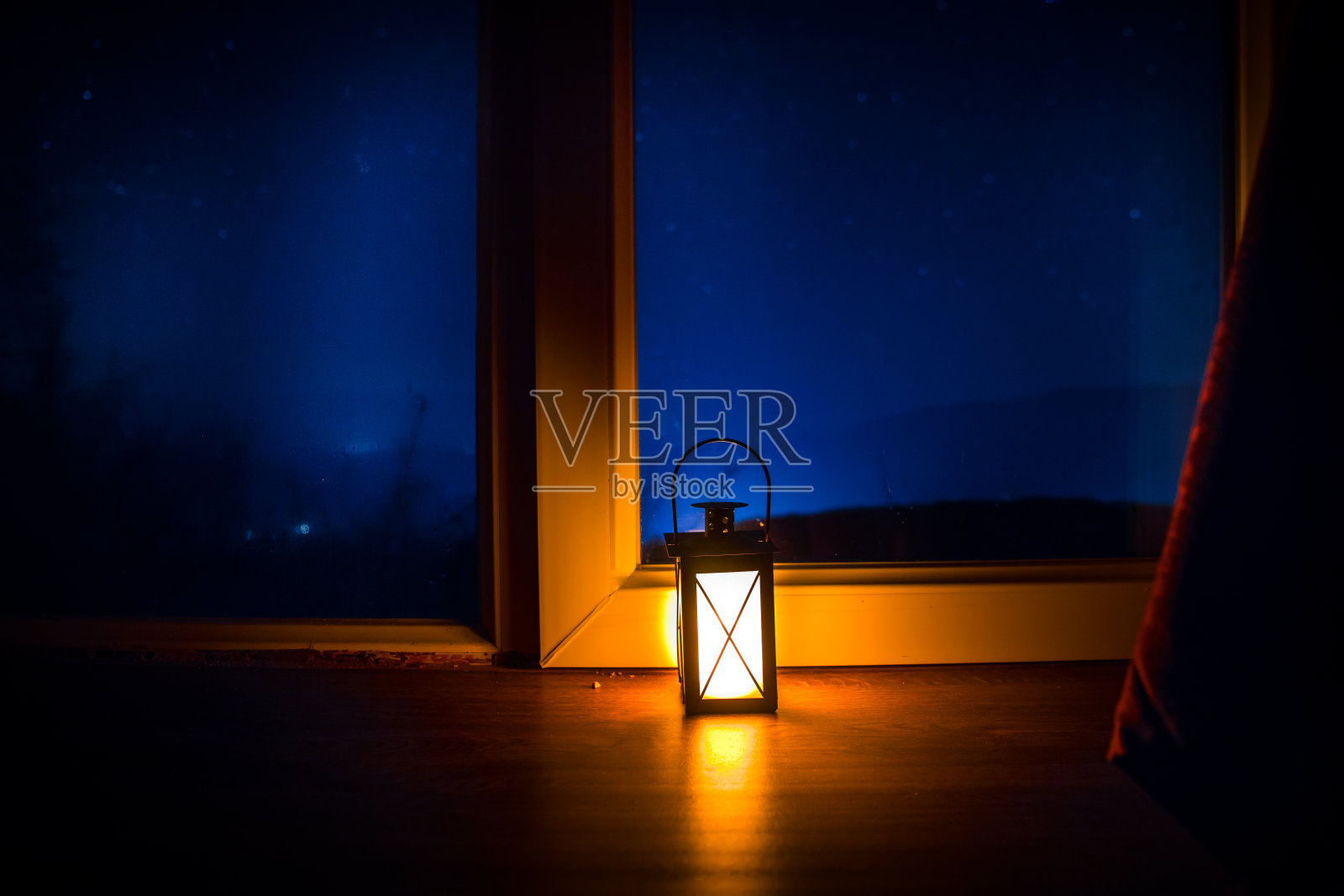 从黑暗的房间里透过窗户看到的星星夜景。暗室里的夜空。长时间曝光拍摄照片摄影图片