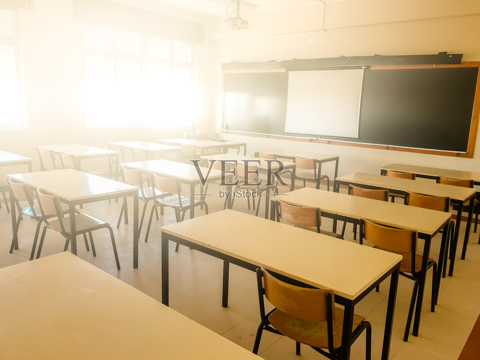 学校教室在模糊的背景中没有年轻的学生;模糊的小学教室，没有孩子或老师在校园桌椅。照片摄影图片