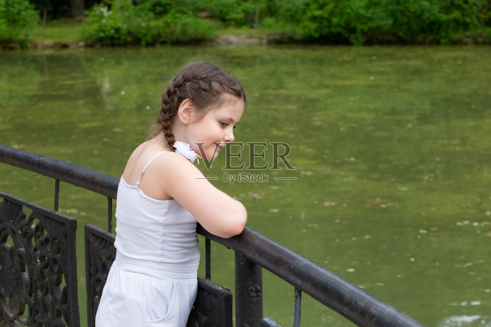 一个欣赏池塘的女孩照片摄影图片