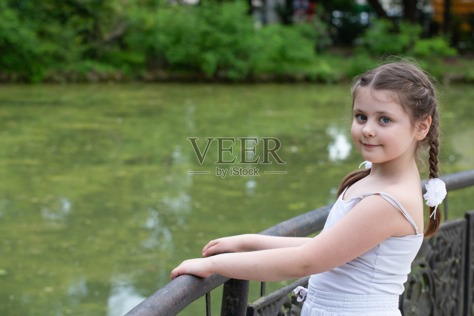 一个美丽的女孩在池塘边照片摄影图片