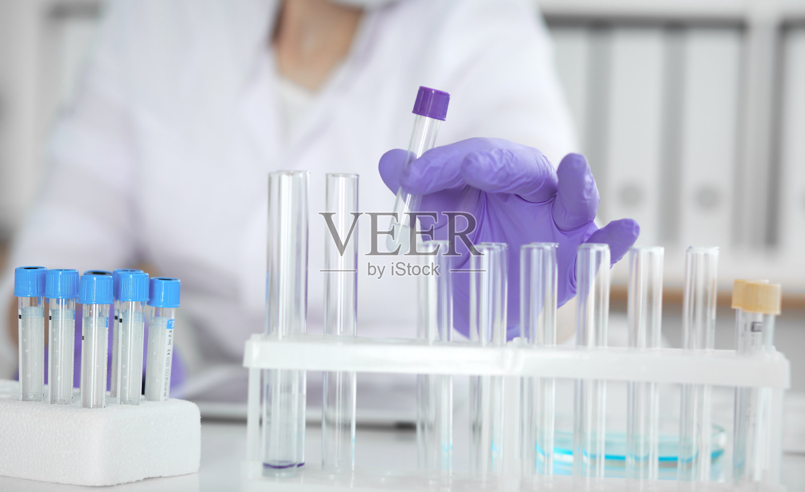 特写的专业女科学家在保护眼镜做实验与试剂在实验室或做血液测试。医学、科学研究概念。照片摄影图片