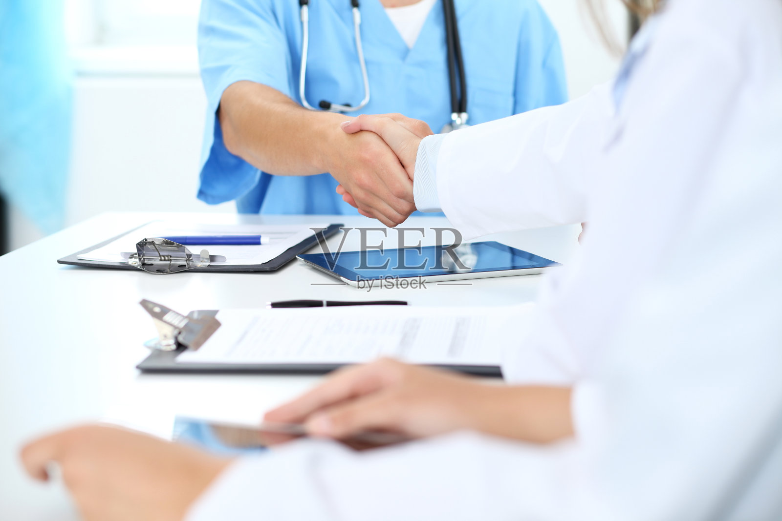 医生们在医学会议结束时互相握手。照片摄影图片